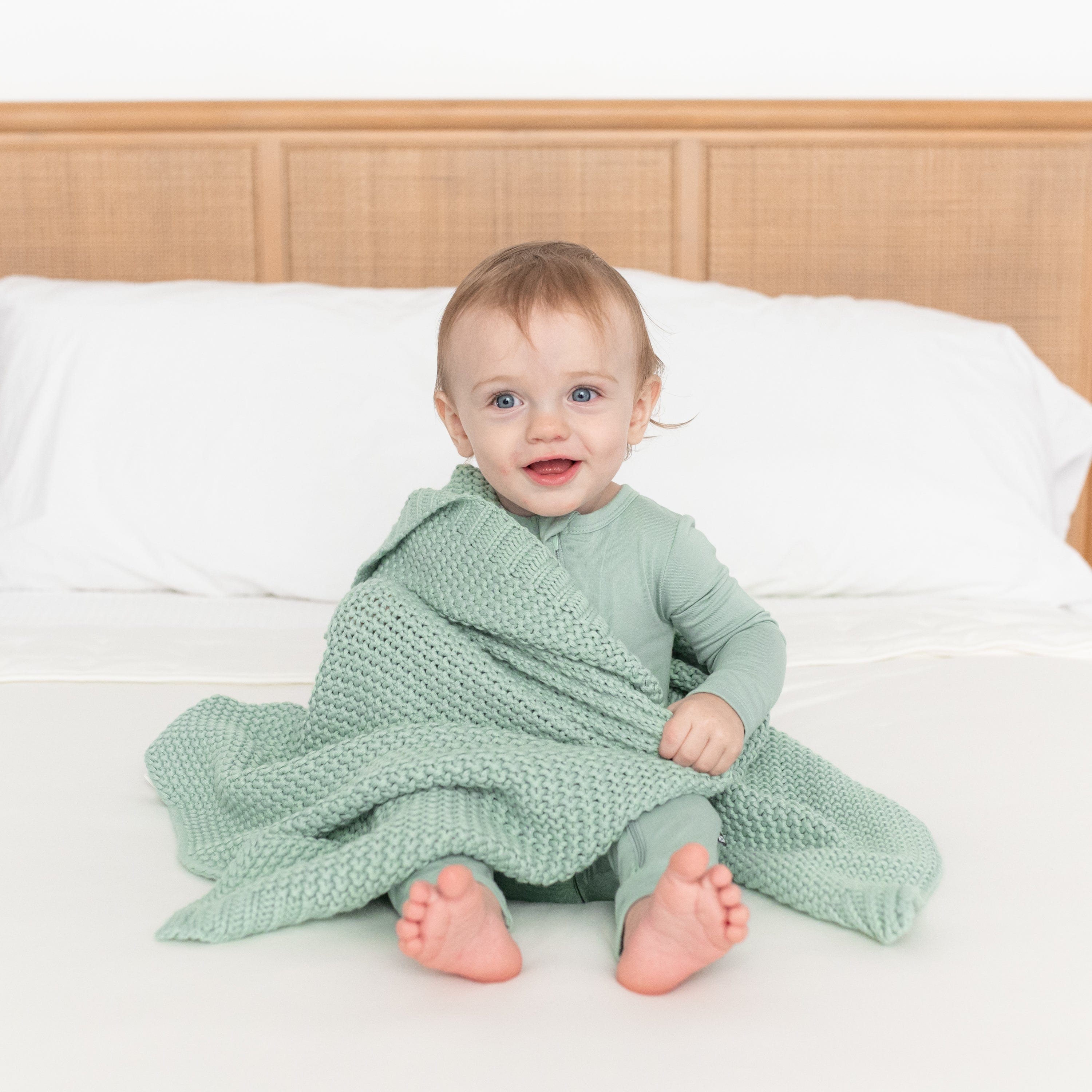 Infant using Kyte Baby Chunky Knit Baby Blanket in Sage