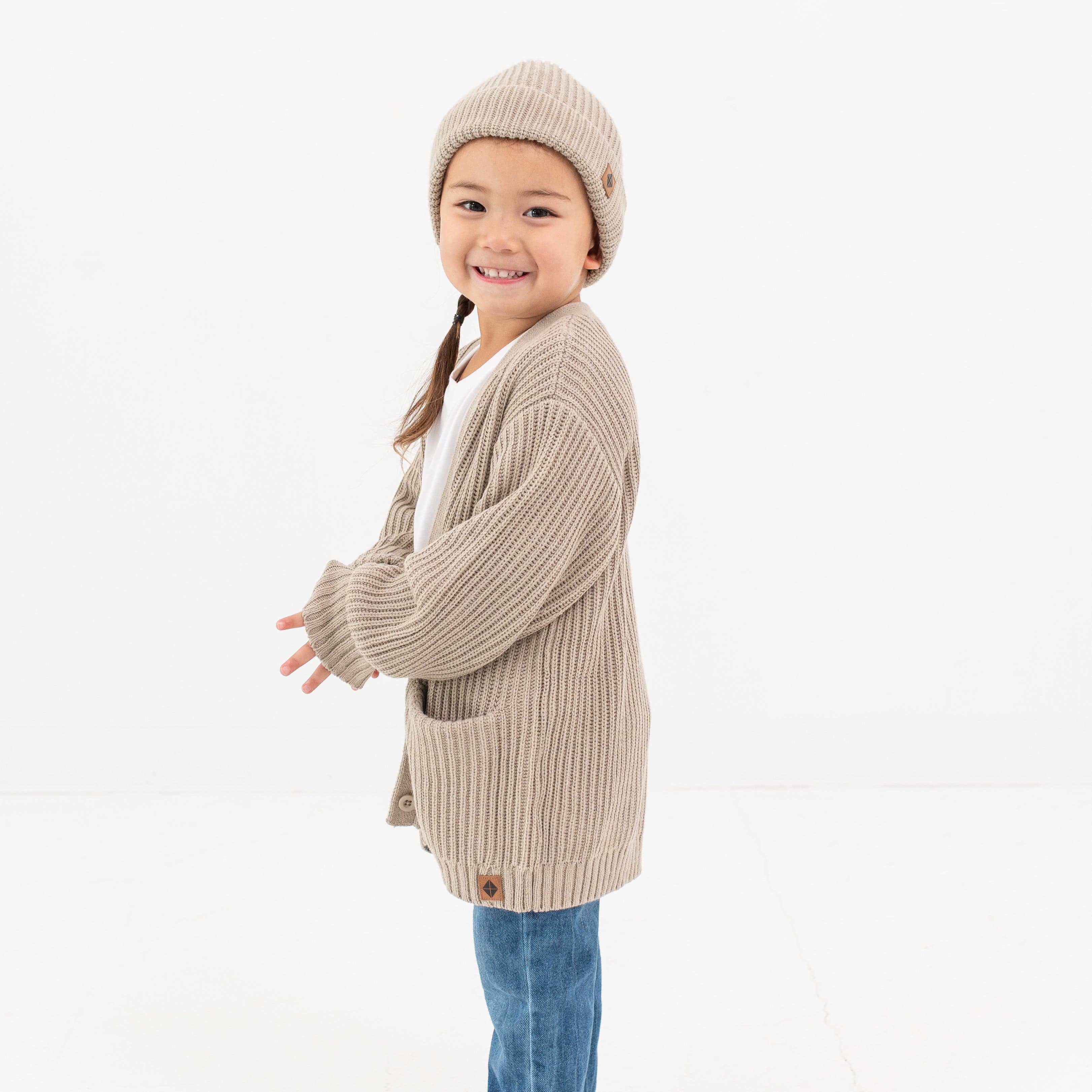 Child wearing Kyte Baby Chunky Knit Oversized Cardigan in Almond