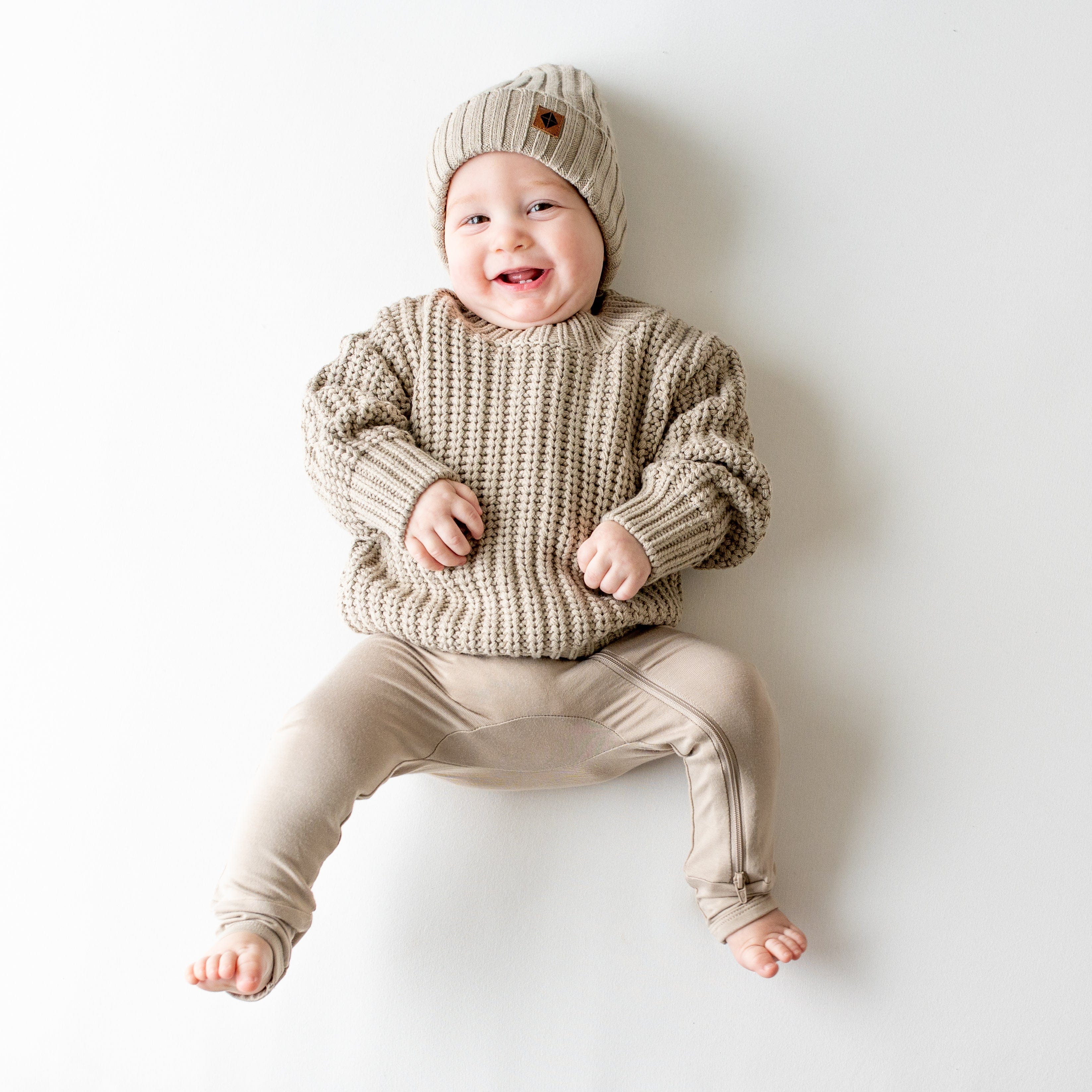 Infant wearing Kyte Baby Chunky Knit Ribbed Beanie in Almond