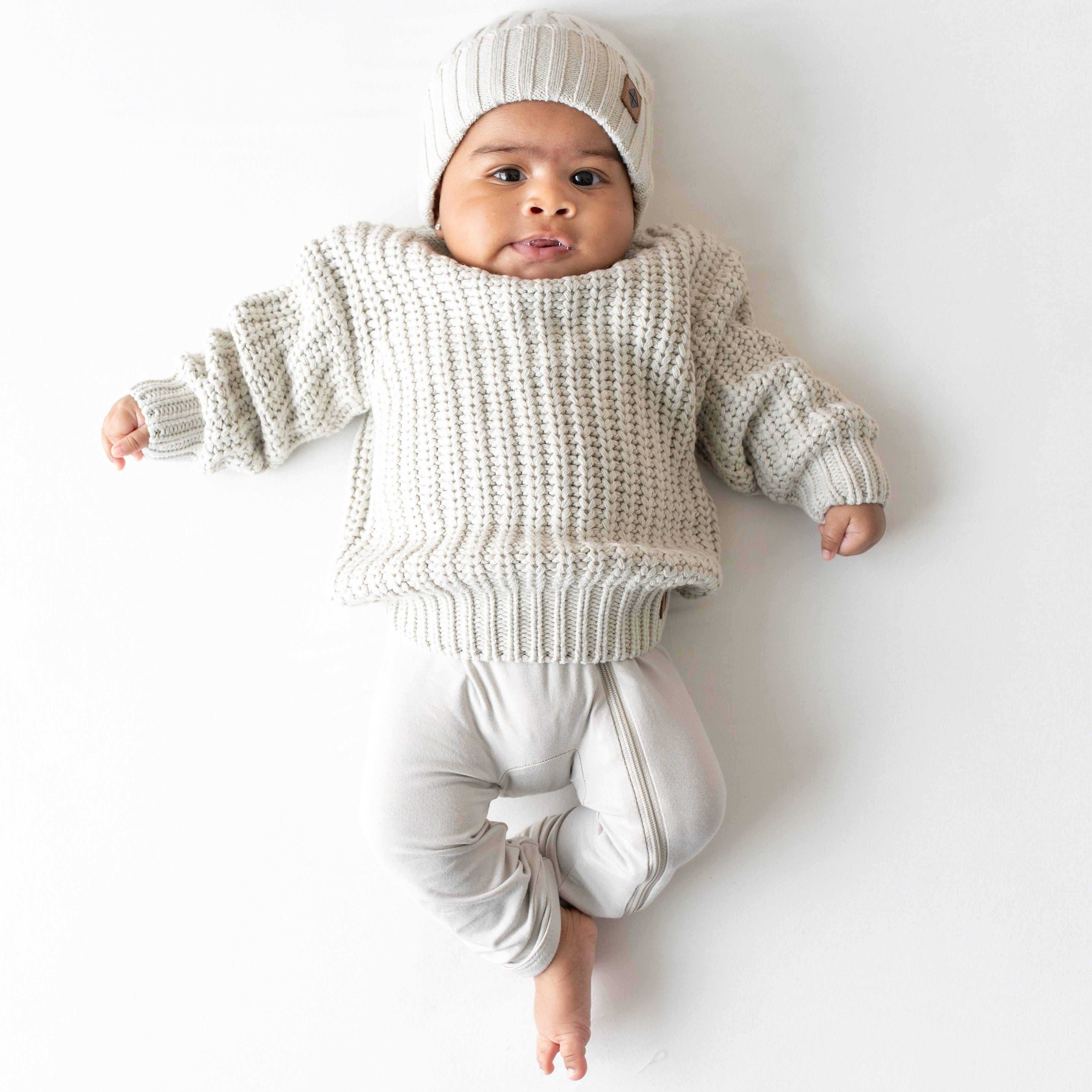 Infant wearing Kyte Baby Chunky Knit Ribbed Beanie in Oat