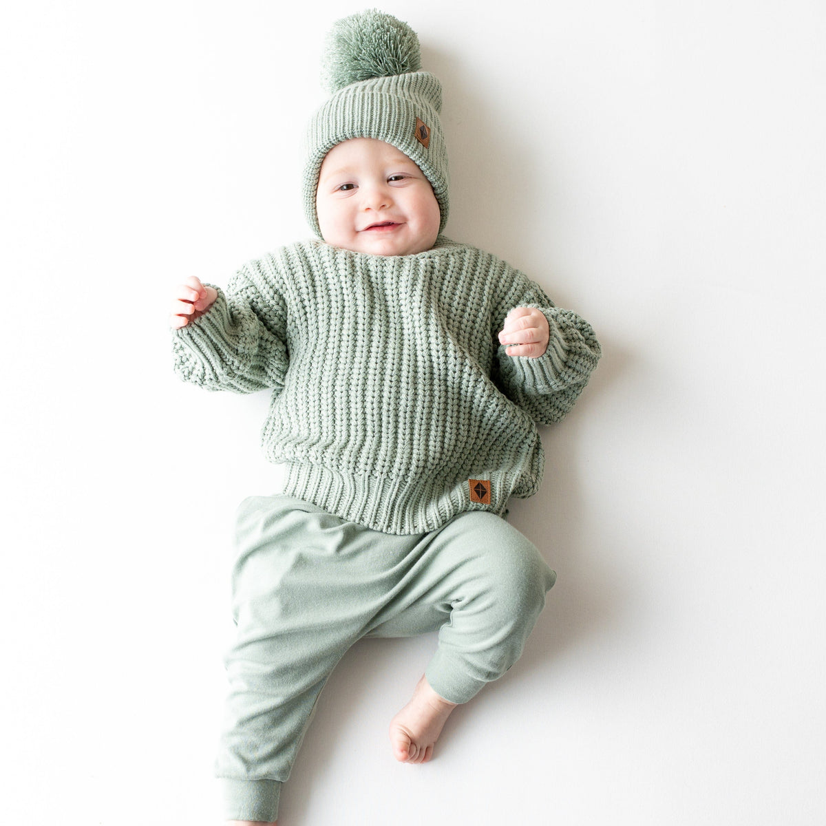 Infant wearing Kyte Baby Chunky Knit Sweater in Thyme