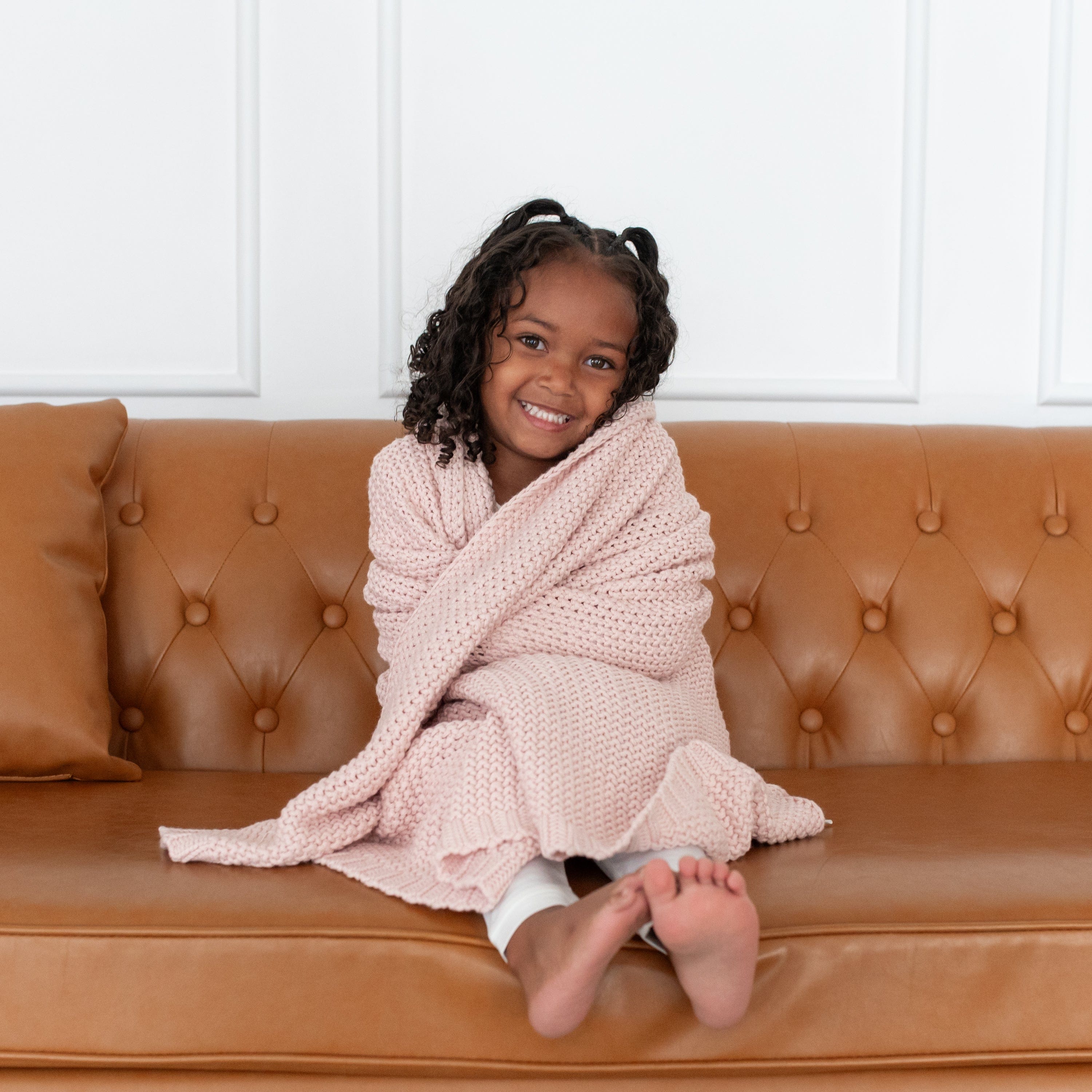Girl using Kyte Baby Chunky Knit Toddler Blanket in Blush