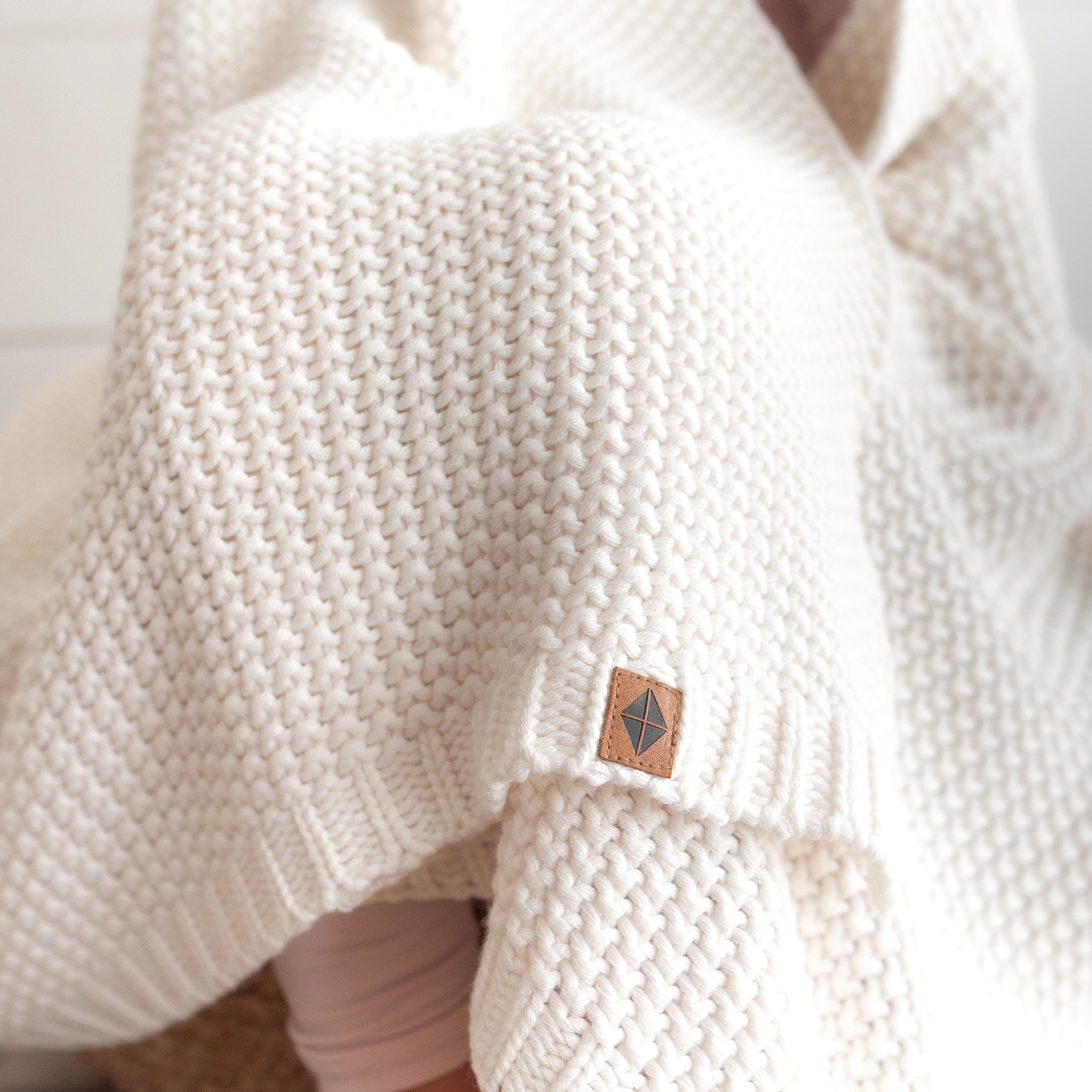 Child using Kyte Baby Chunky Knit Toddler Blanket in Cloud