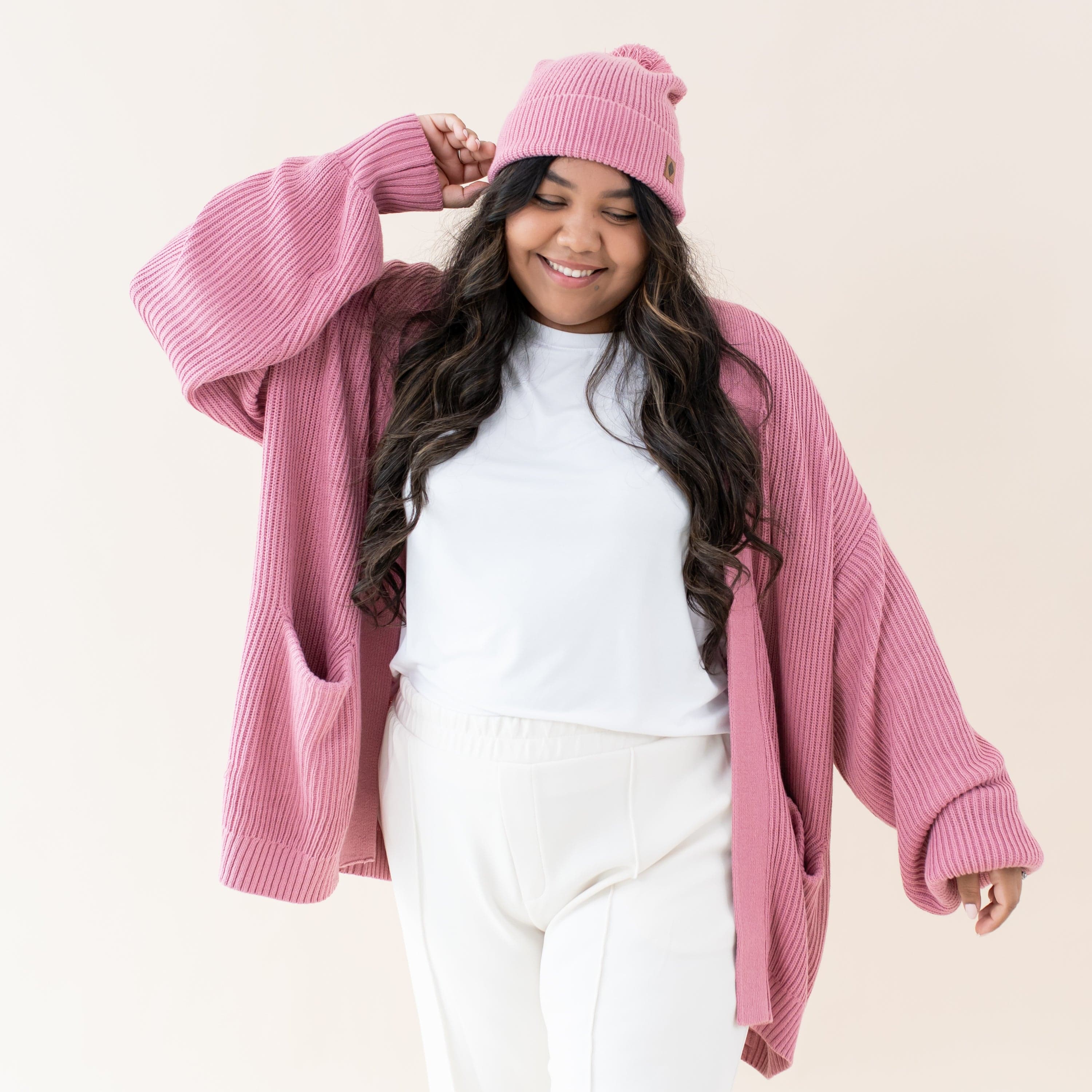 Woman wearing Kyte Baby Chunky Knit Oversized Cardigan with Front Pockets in Apple Blossom