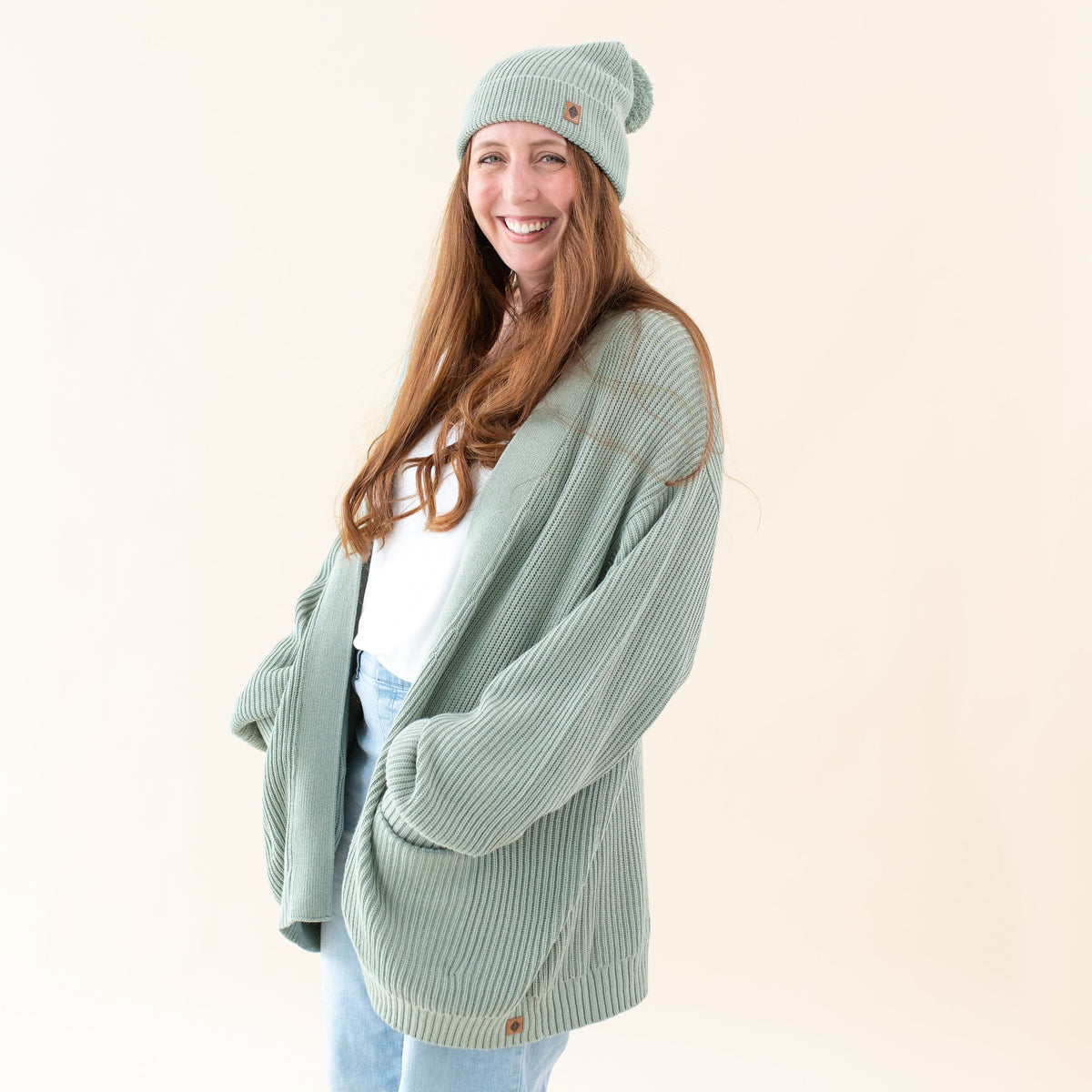 Woman wearing Kyte Baby Chunky Knit Women's Oversized Cardigan in Thyme