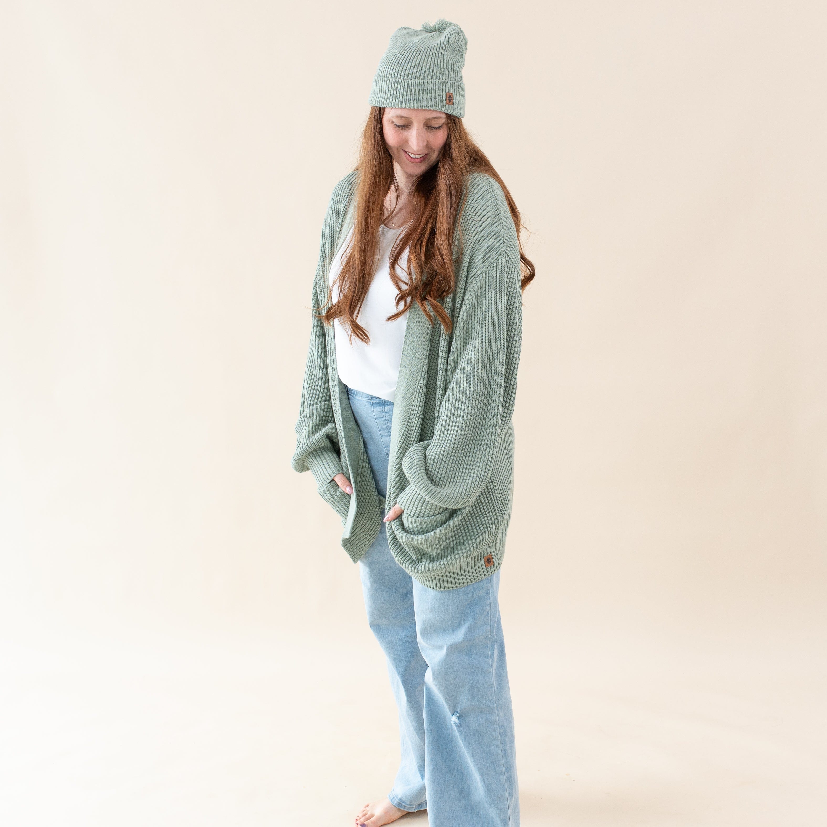 Woman wearing Kyte Baby Chunky Knit Oversized Cardigan with Front Pockets in Thyme green
