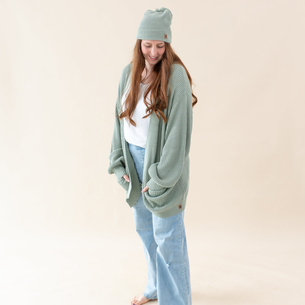Woman wearing Kyte Baby Chunky Knit Oversized Cardigan with Front Pockets in Thyme green