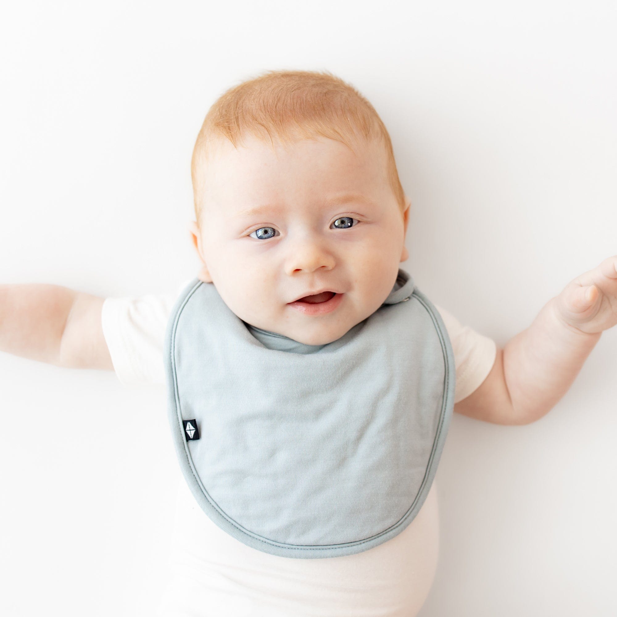 Infant wearing Kyte Baby Cushy Bib in Fog