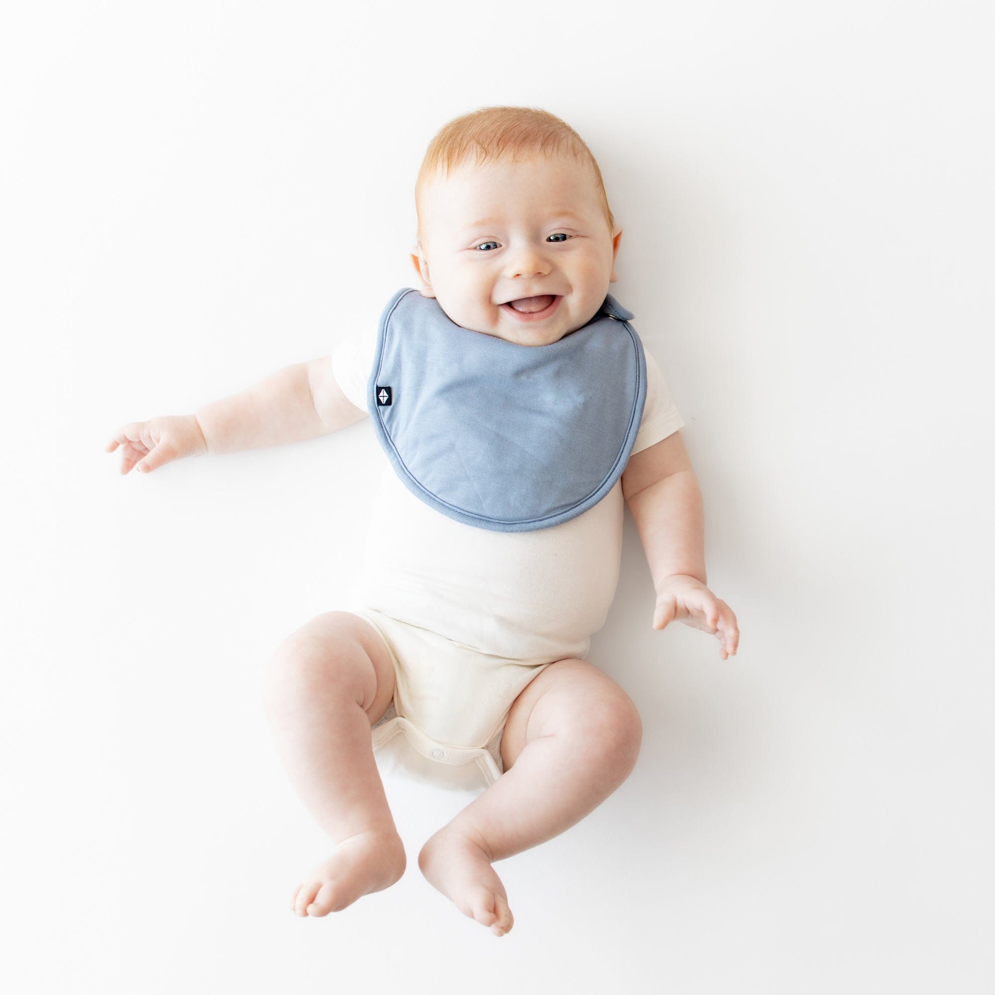 Infant wearing Kyte Baby Cushy Bib with Adjustable Snaps in Slate