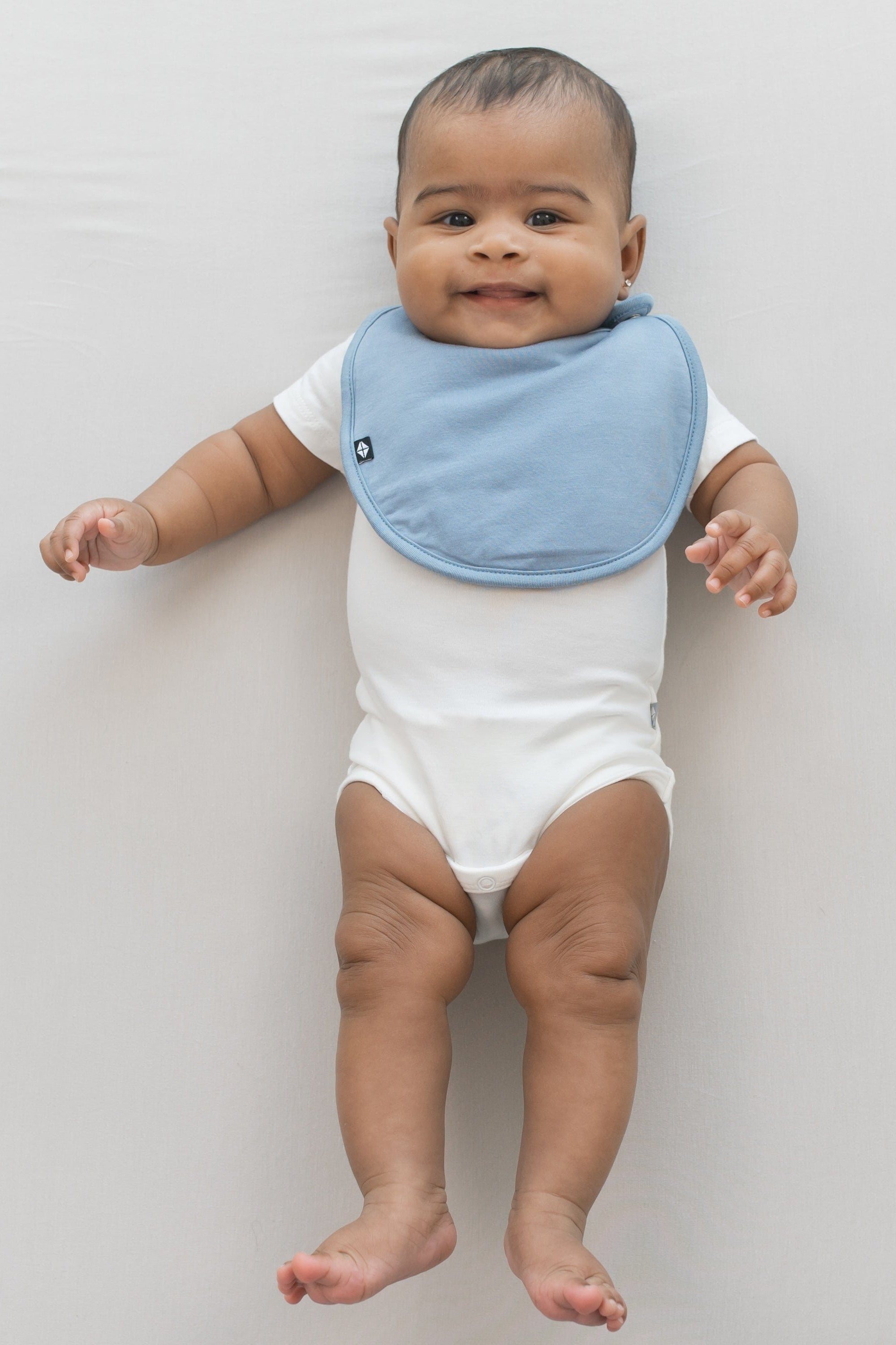 Infant wearing Kyte Baby Cushy Bamboo Bib in Slate blue