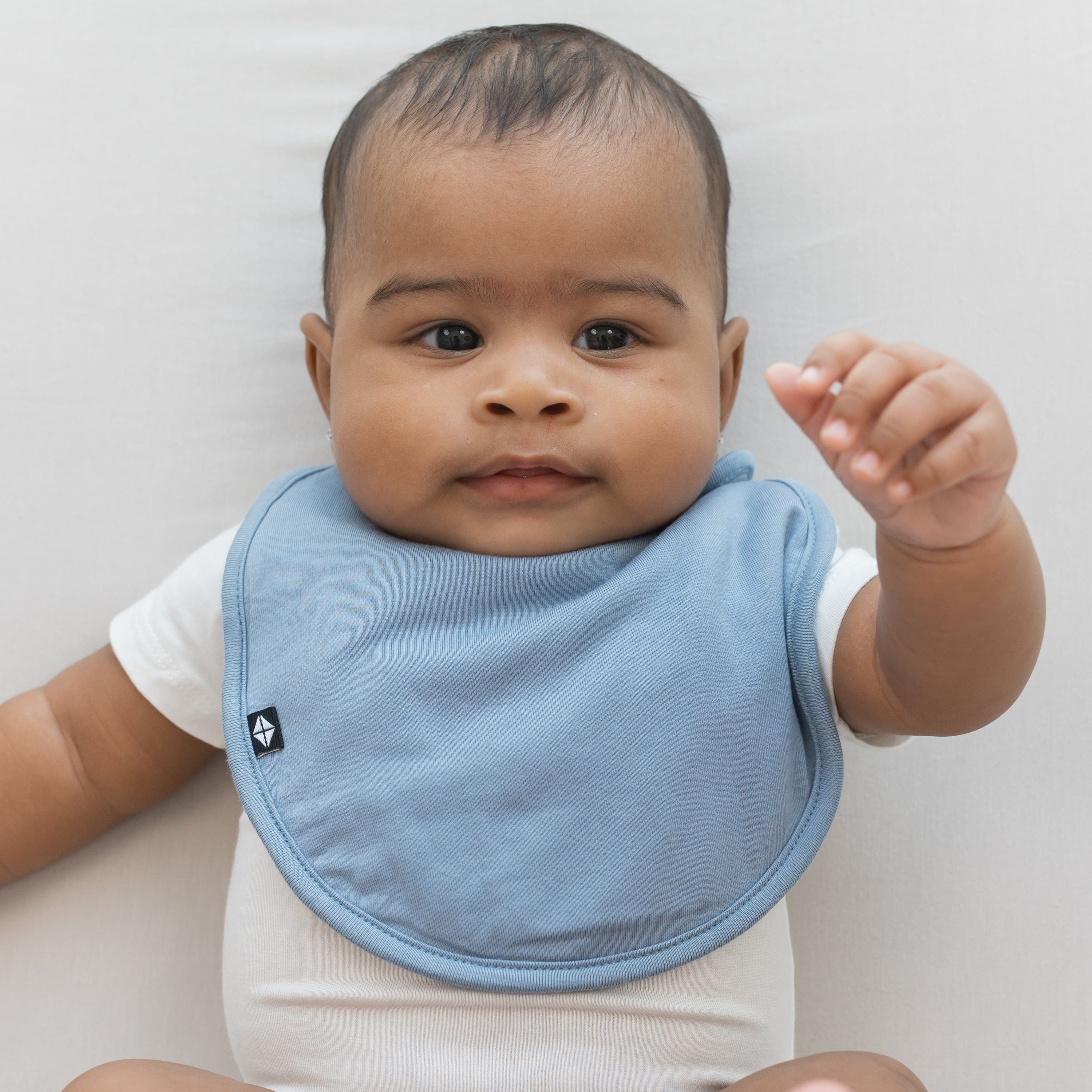 Infant wearing Kyte Baby Cushy Bib in Slate