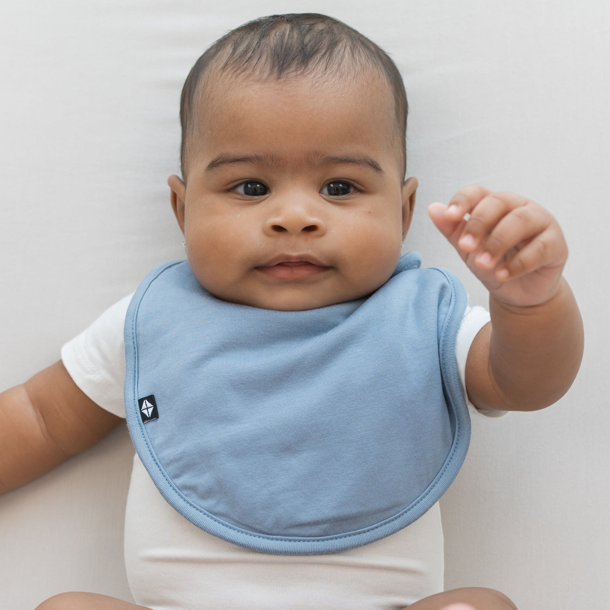 Infant wearing Kyte Baby Cushy Bib in Slate