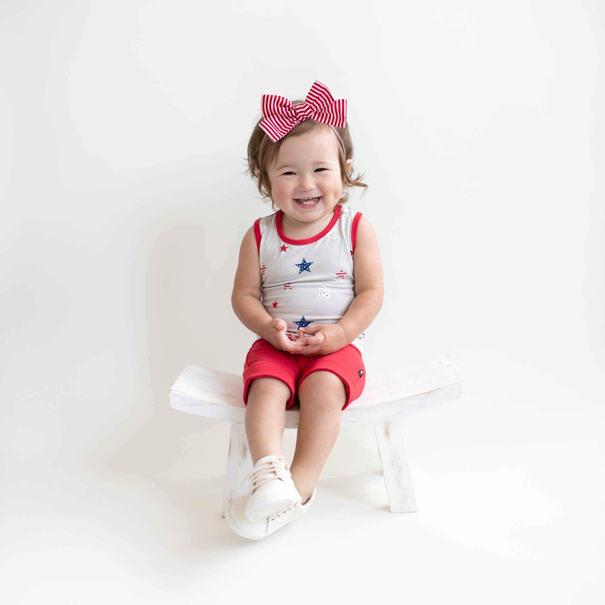 Toddler wearing Kyte Baby Harem Shorts with cuffed edges in Cardinal red