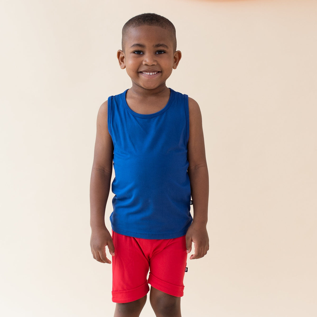Boy wearing Kyte Baby Harem Shorts in Cardinal