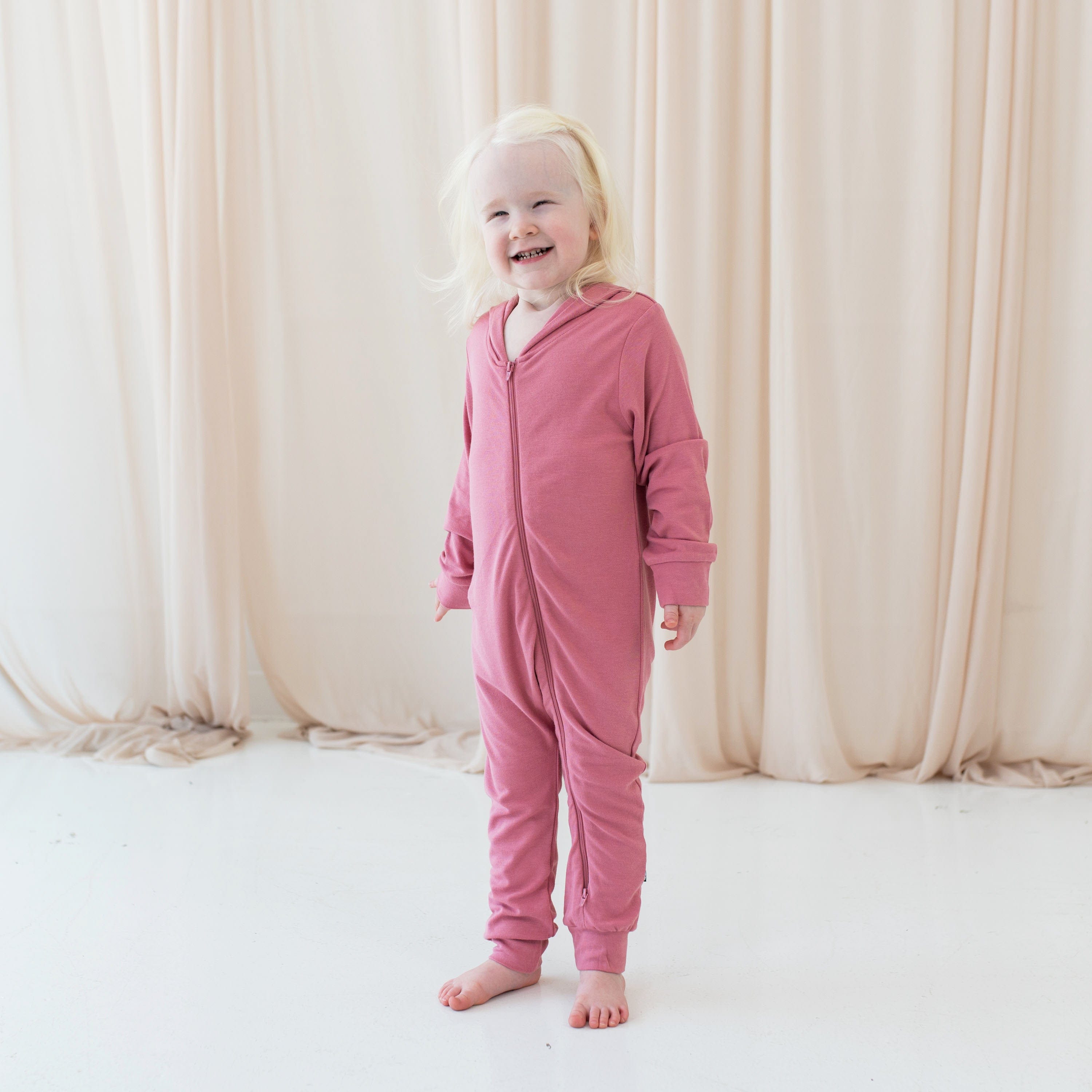 Girl wearing zippered romper with hood in Apple Blossom