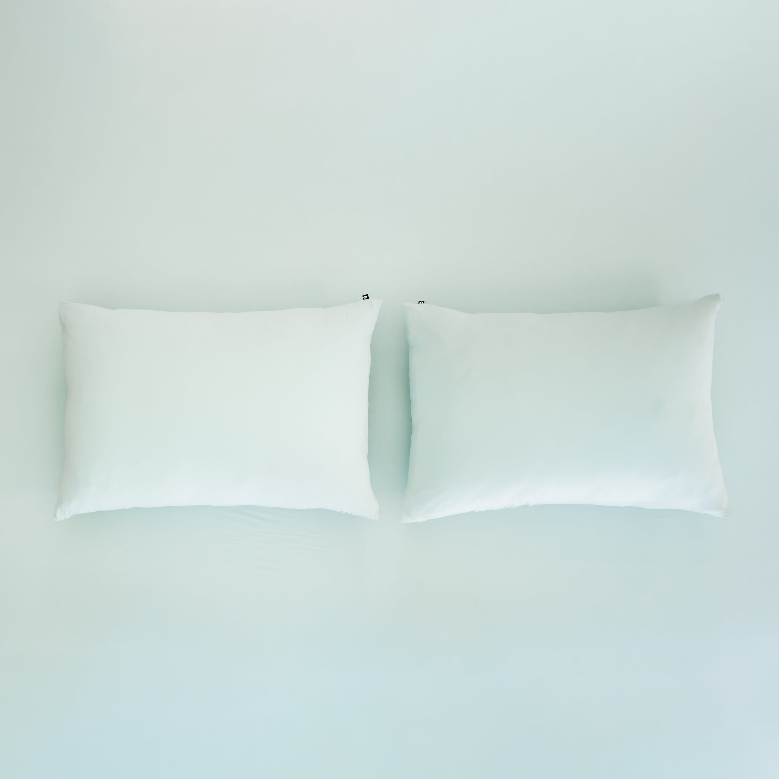 Kyte Baby Pillowcases in Sage sitting on fitted sheet