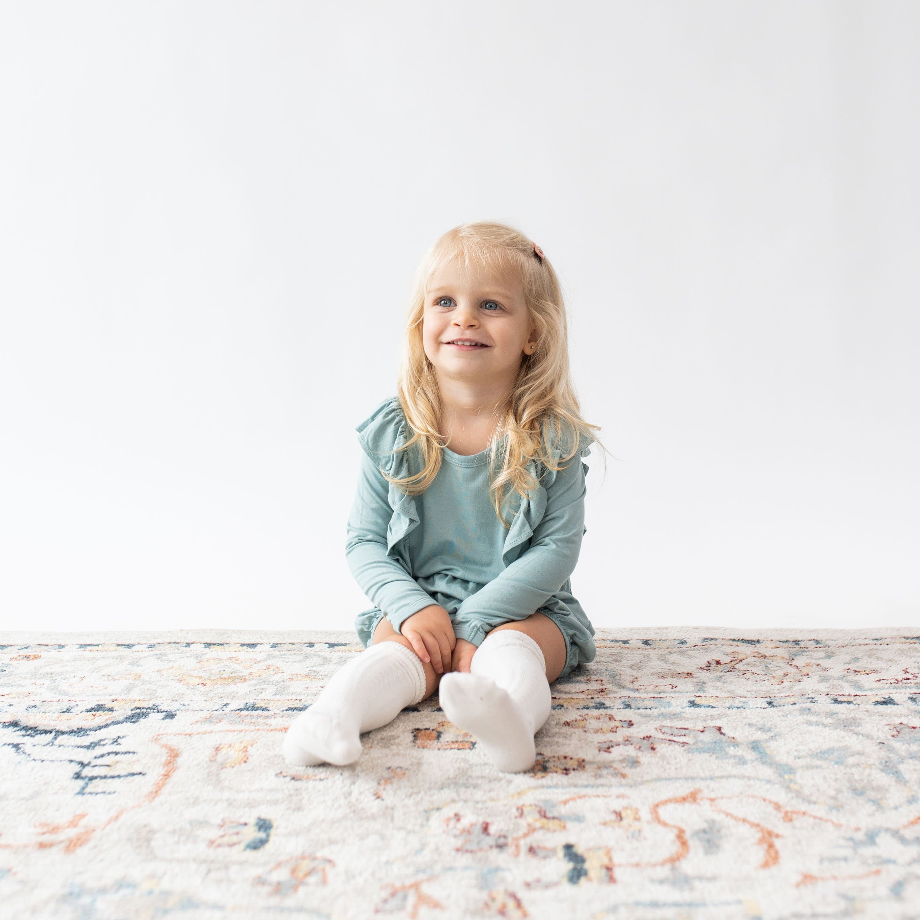 Toddler wearing Kyte Baby bamboo Knee High Socks in Cloud white