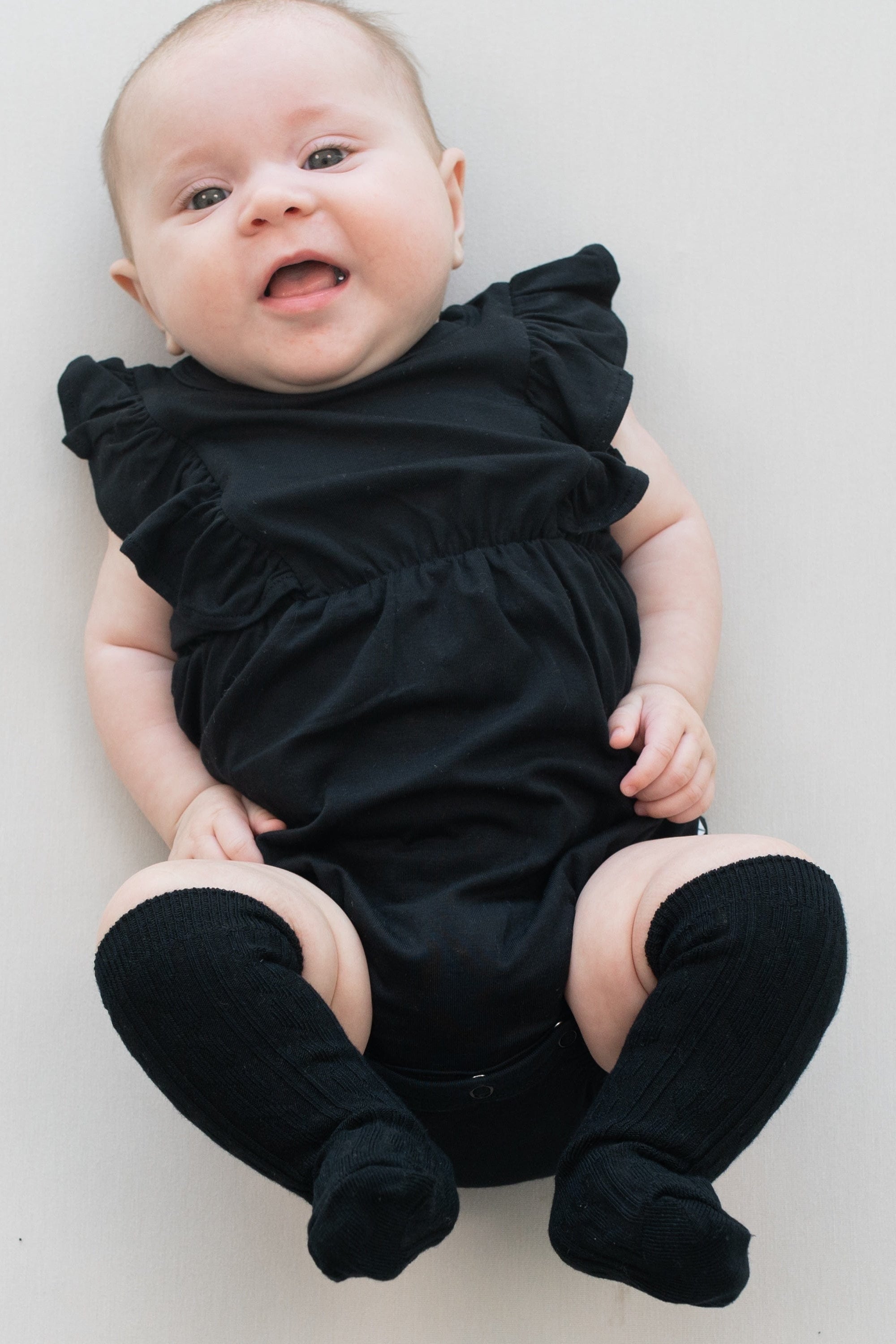 Infant wearing Kyte Baby cable knit Knee High Socks in Midnight