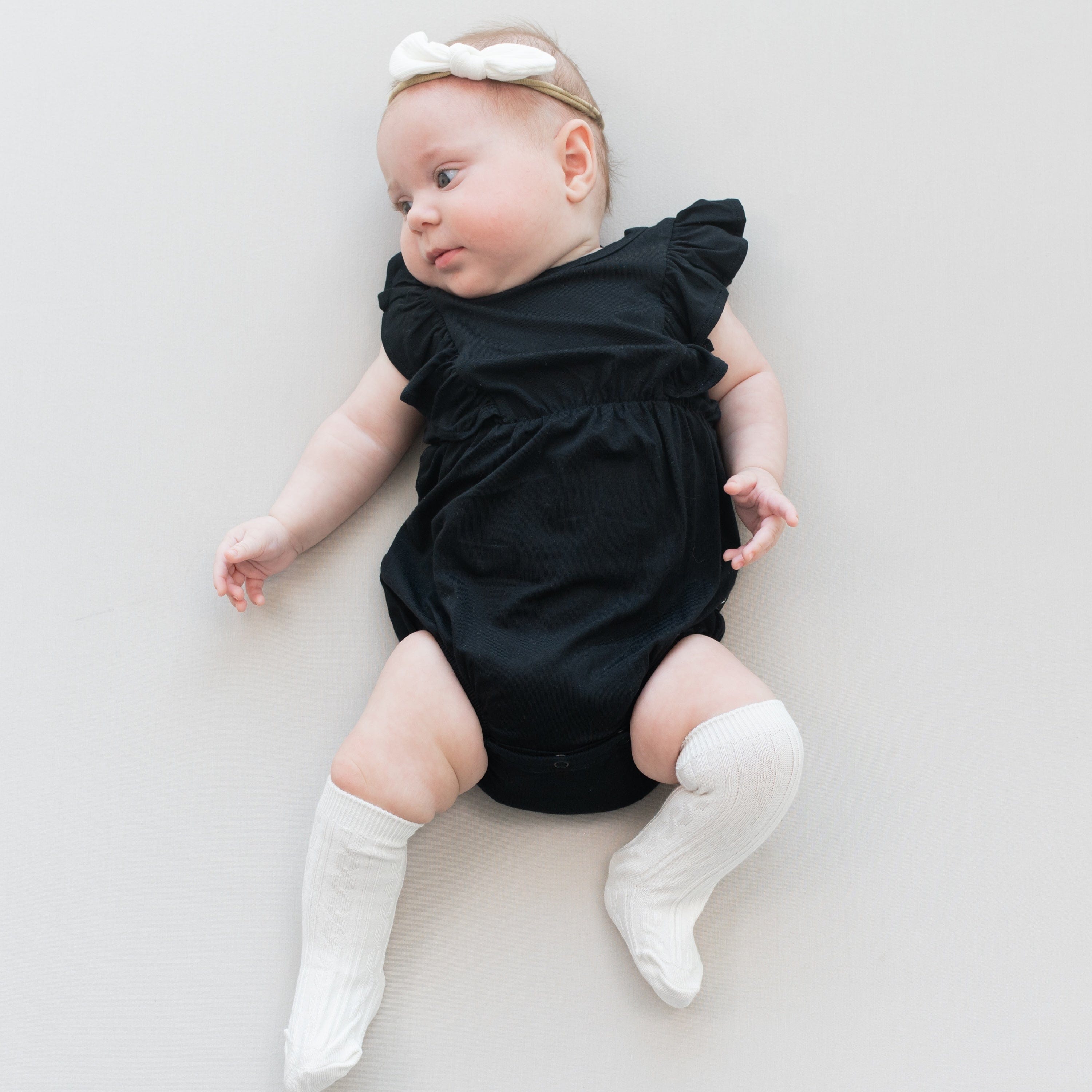 Infant wearing Kyte Baby Knee High Socks with ribbed cuff in Oat
