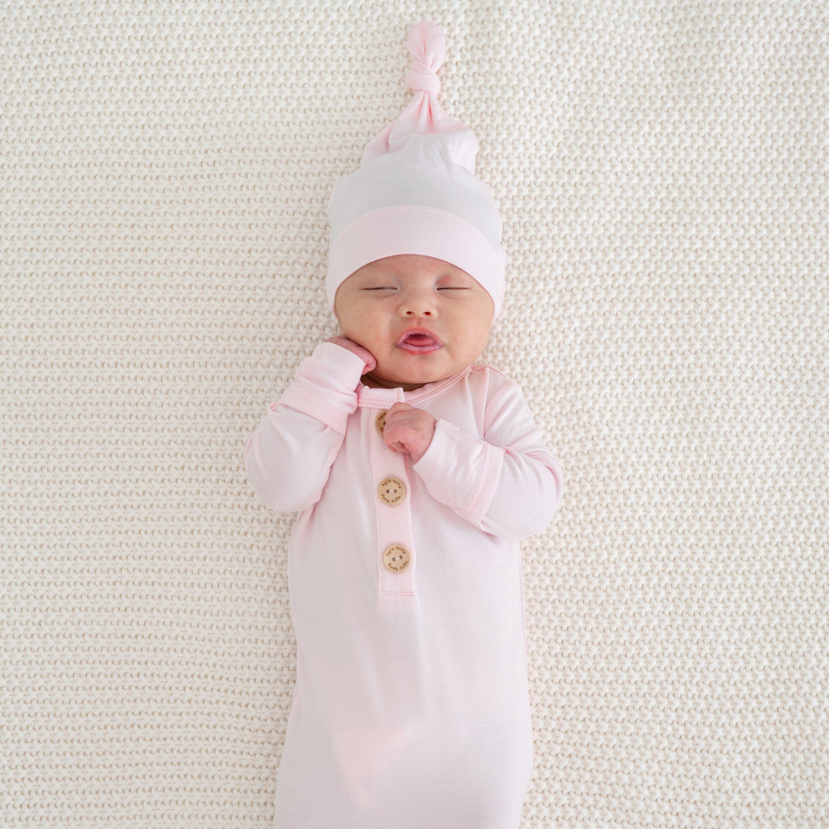 Newborn wearing Kyte Baby Knotted Cap in Sakura