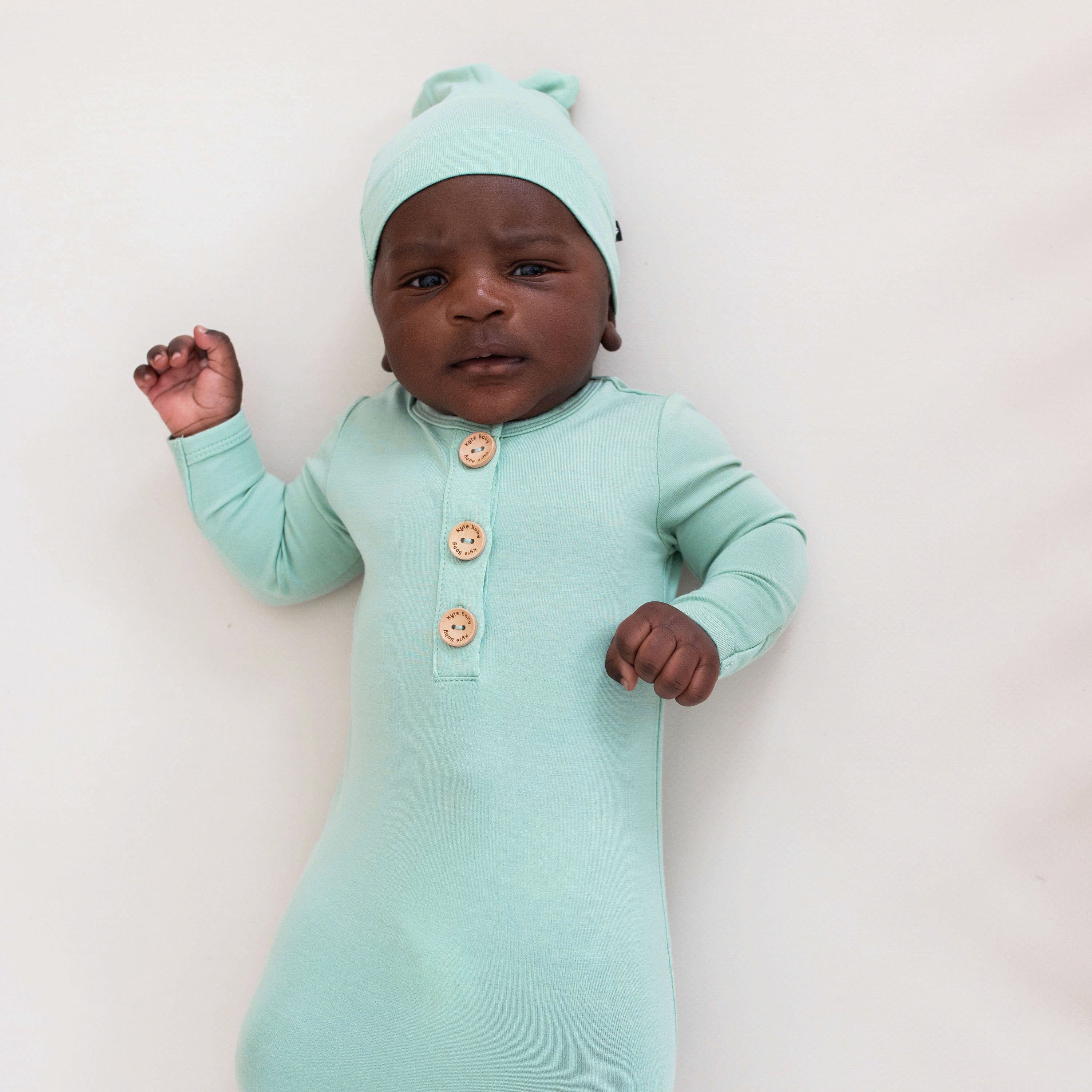 Newborn wearing Kyte Baby Knotted Cap in Wasabi