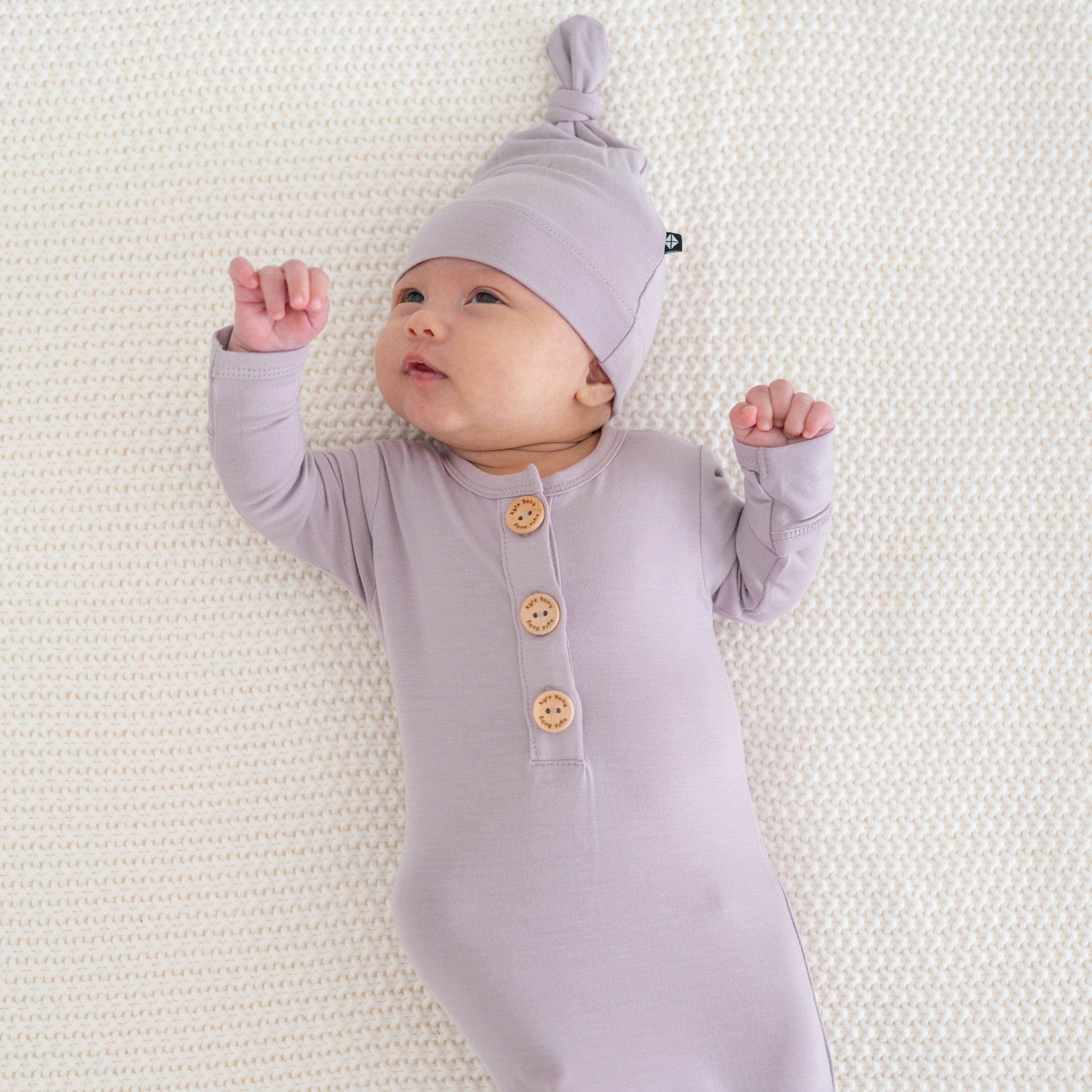 Newborn wearing Kyte Baby Knotted Cap in Wisteria purple