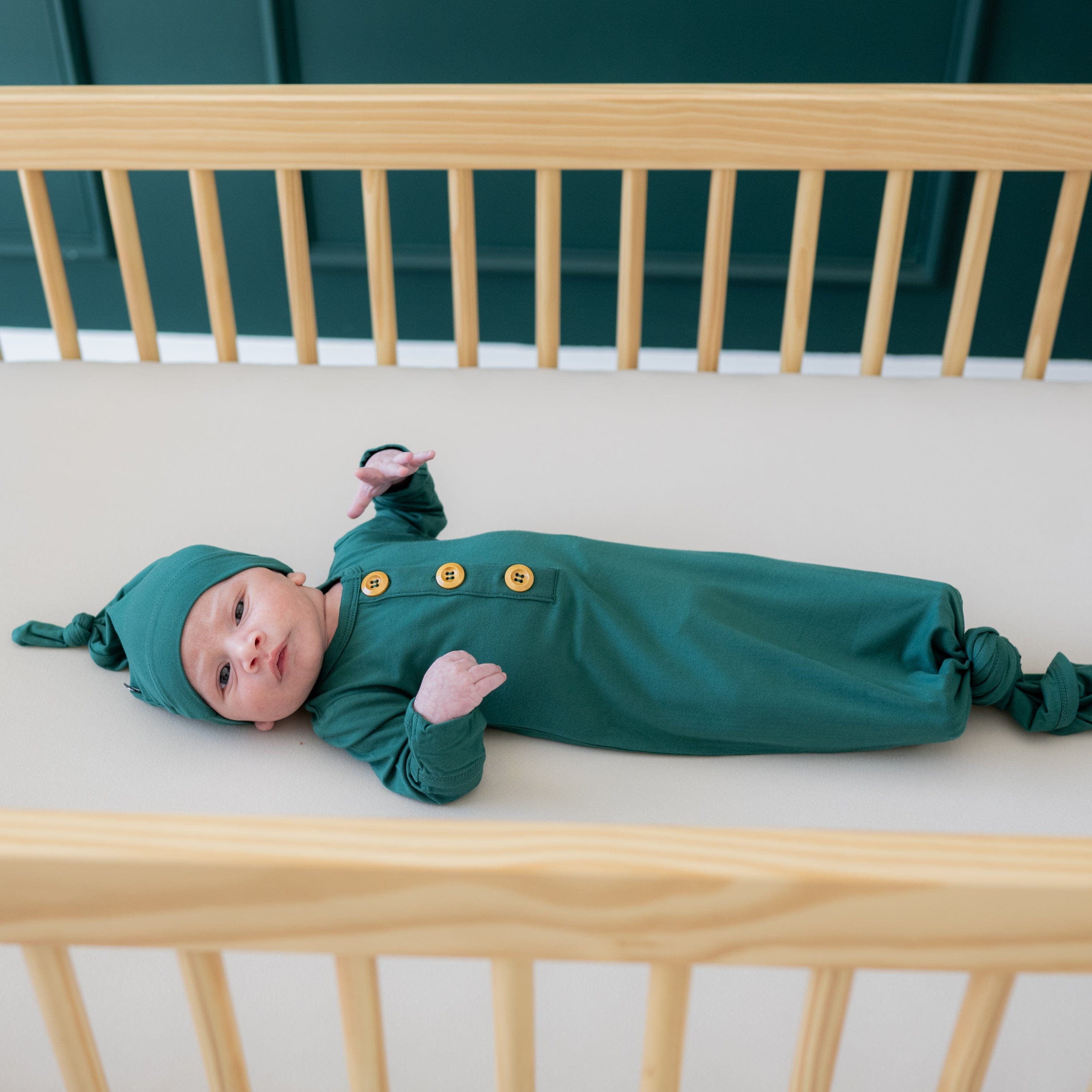 Infant wearing Kyte Baby bamboo Knotted Gown with Hat Set in Emerald