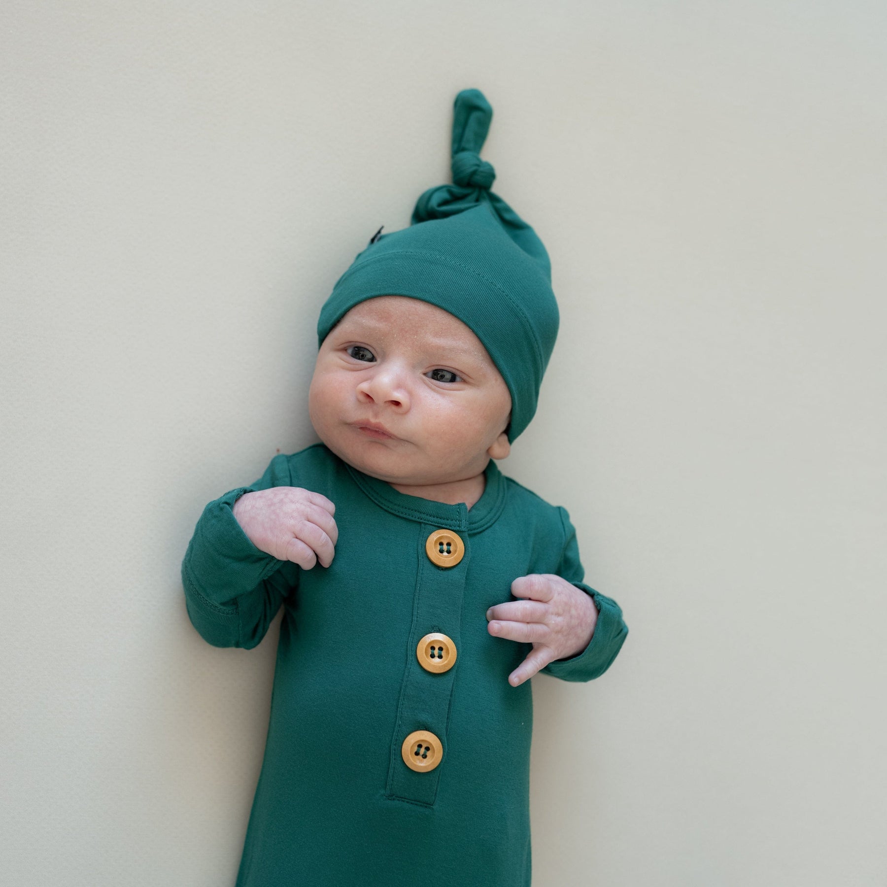 Baby wearing Kyte Baby Knotted Gown with Hat Set in Emerald