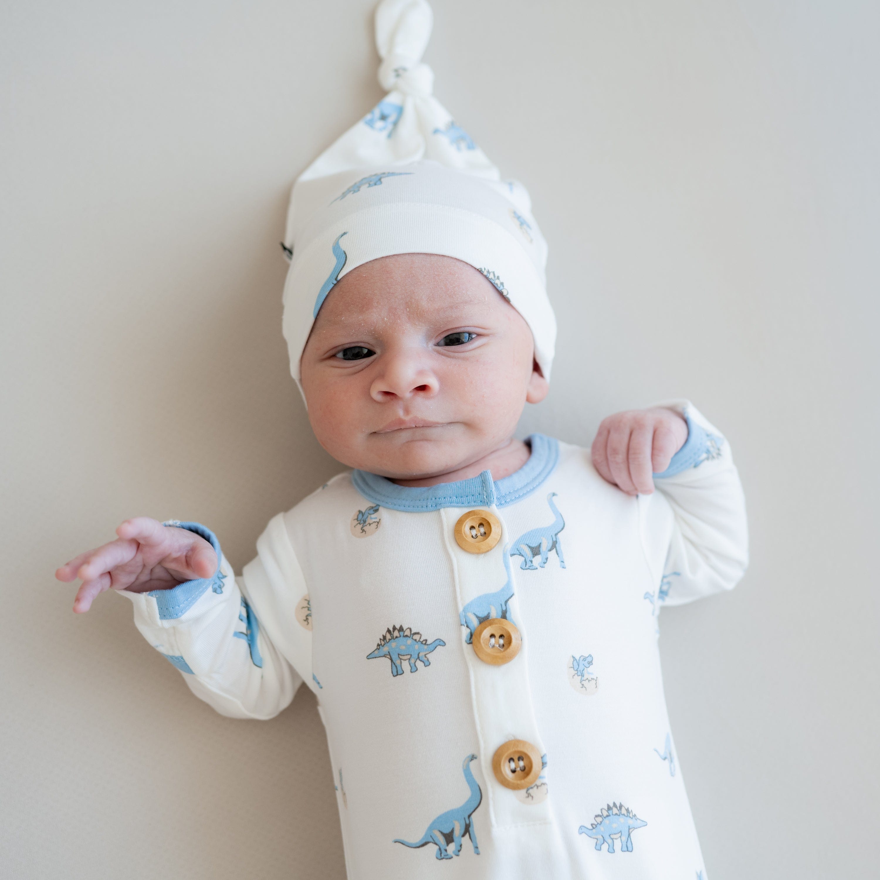 Infant wearing Kyte Baby bamboo Knotted Gown with Hat Set in Jurassic