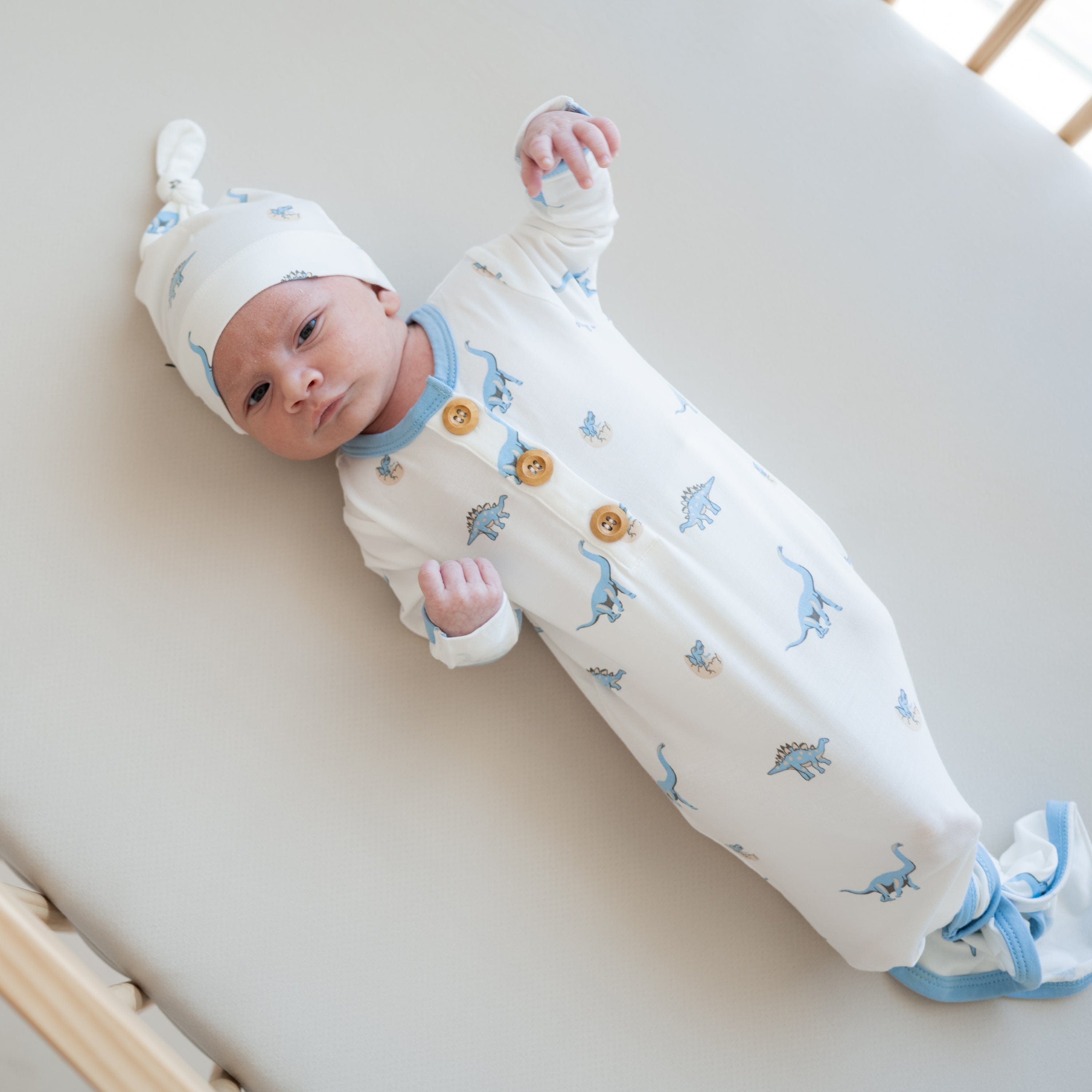 Newborn wearing Kyte Baby Knotted Gown with Hat Set in Jurassic