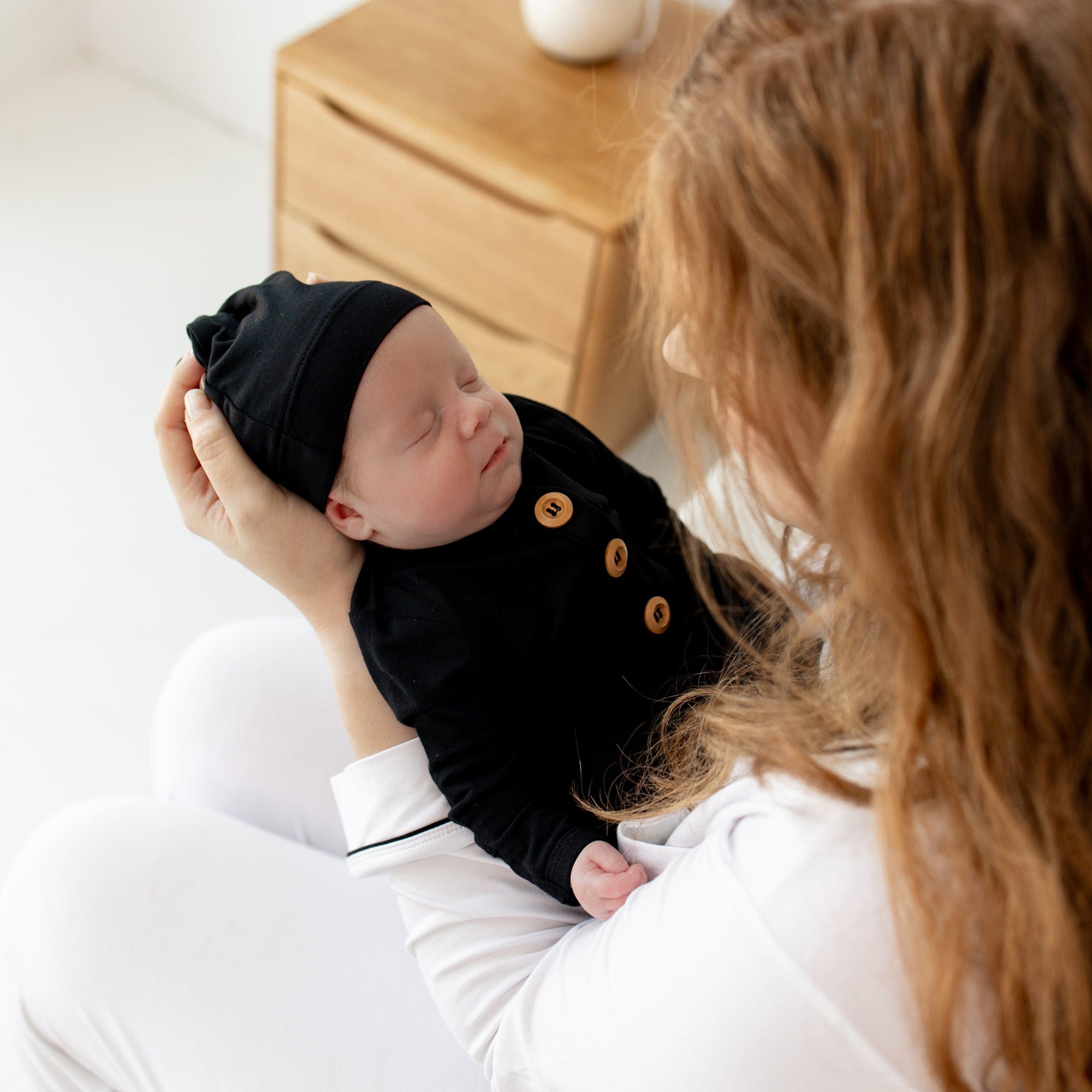 Sleeping newborn being held by mother in Knotted Gown with Hat Set in Midnight