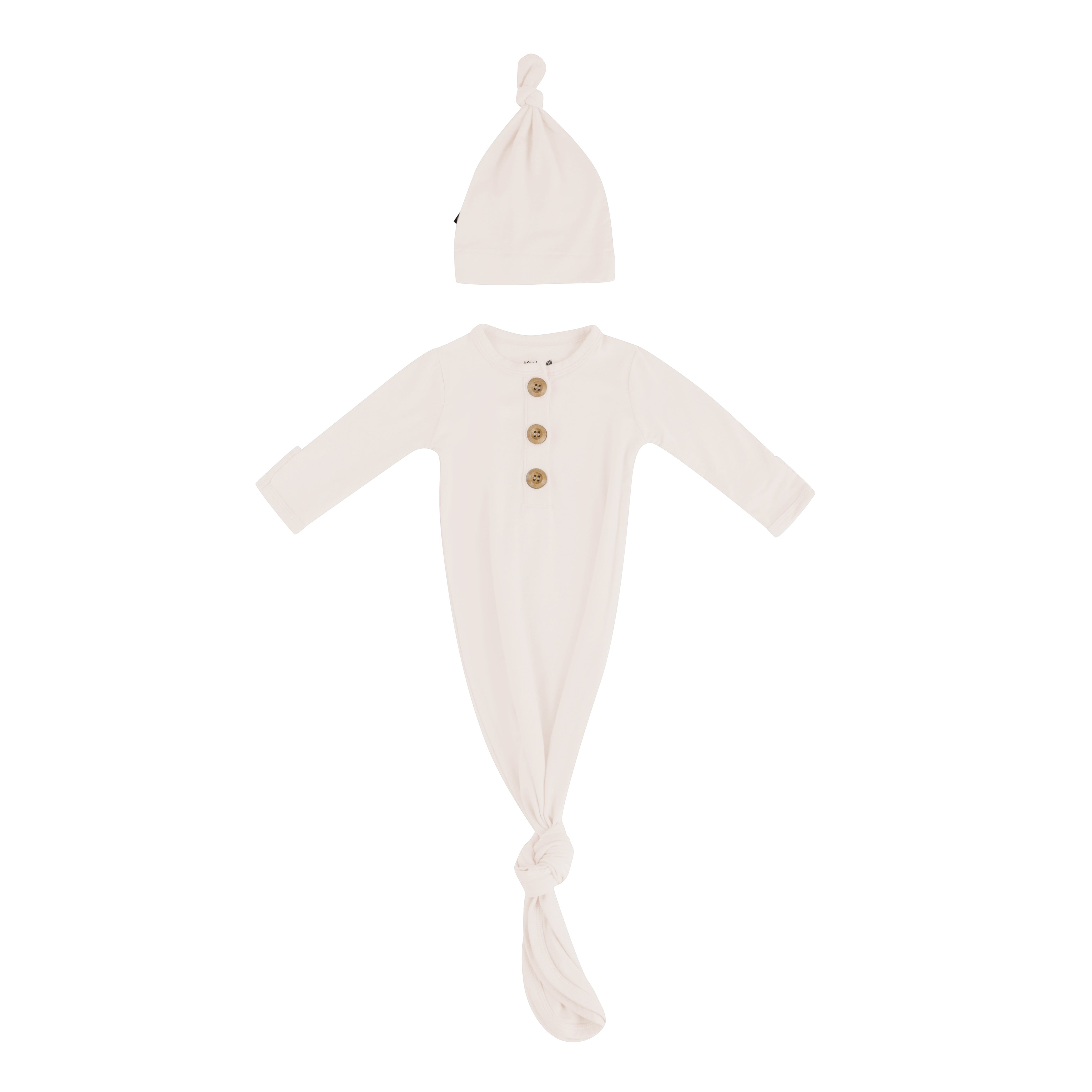 Flat lay of Kyte Baby Knotted Gown with Hat Set in Oat