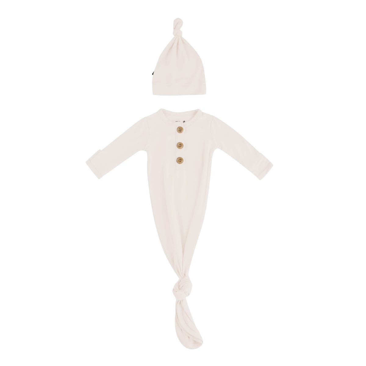 Flat lay of Kyte Baby Knotted Gown with Hat Set in Oat