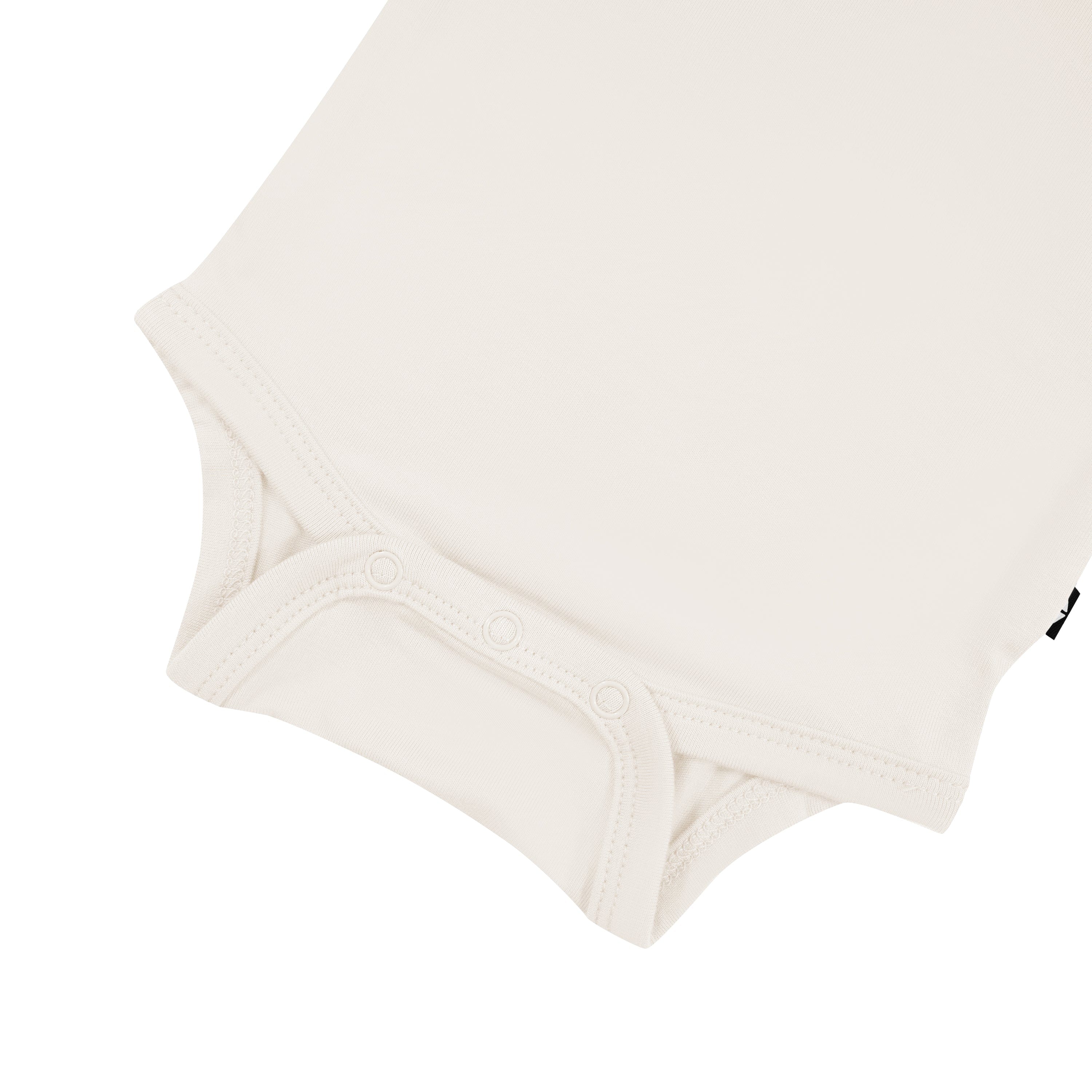 Snap bottom of Kyte Baby Long Sleeve Bodysuit in Oat