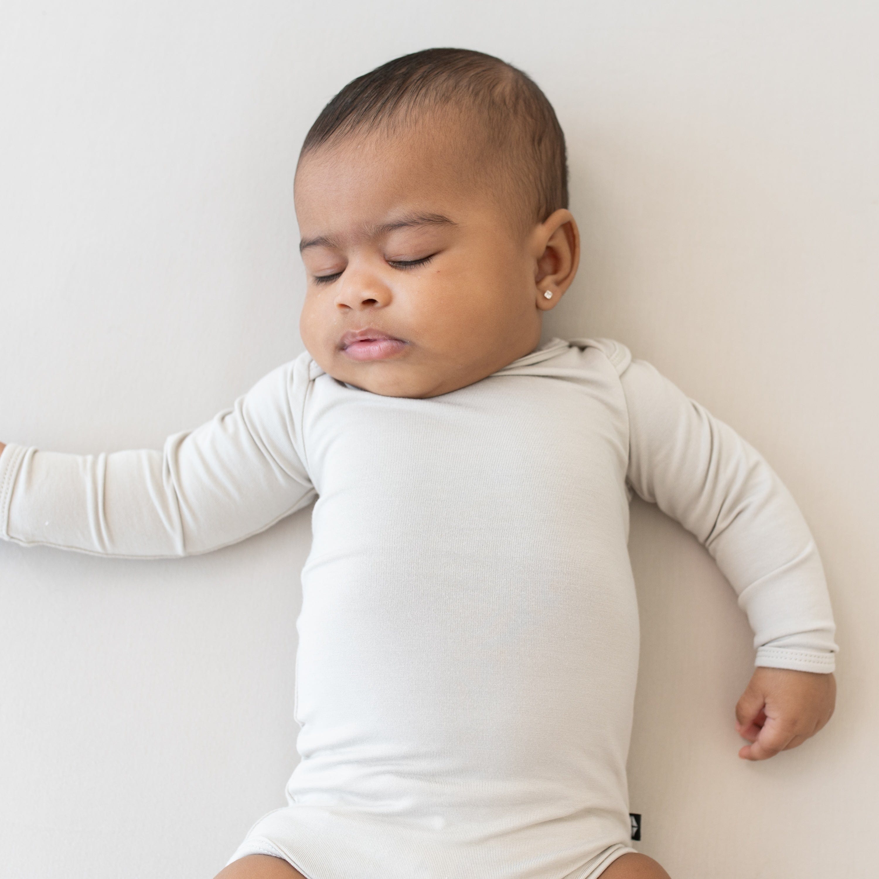 Close up of sleeping baby wearing a Long Sleeve Bodysuit in Oat