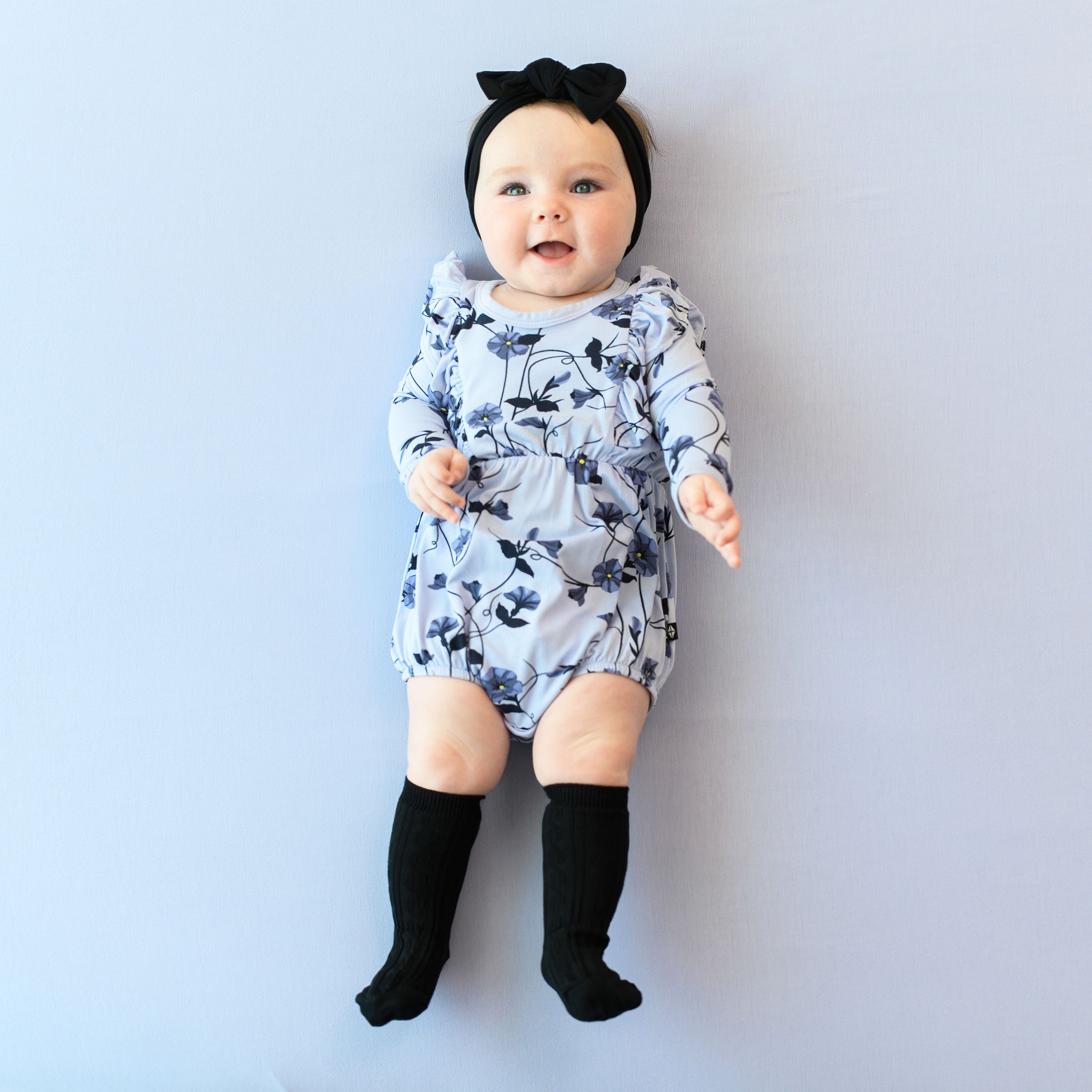 Infant wearing Kyte Baby Long Sleeve Bubble Romper in Petunia