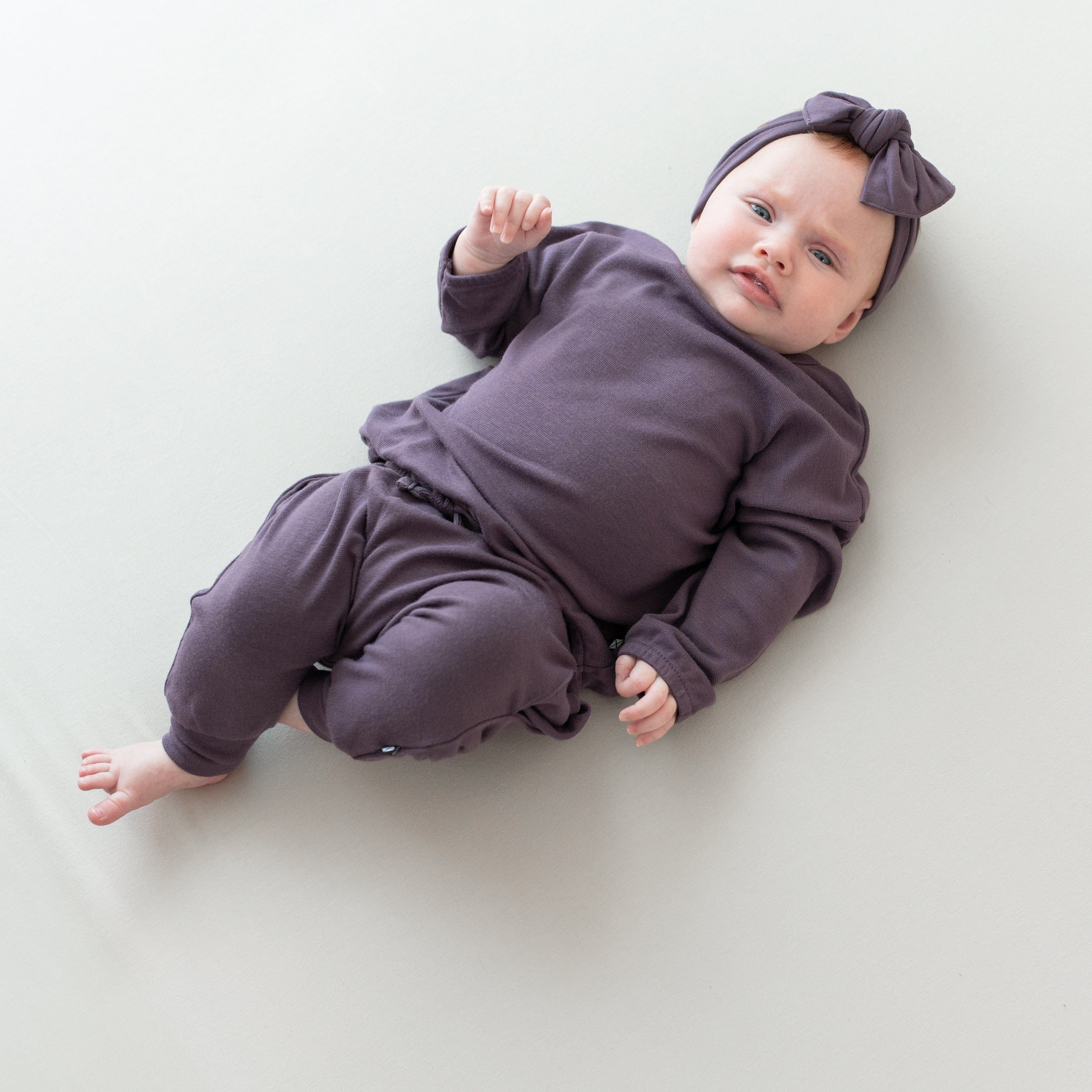 Infant wearing Kyte Baby Bamboo Jersey Drop Shoulder Top with Crew Neck in Currant