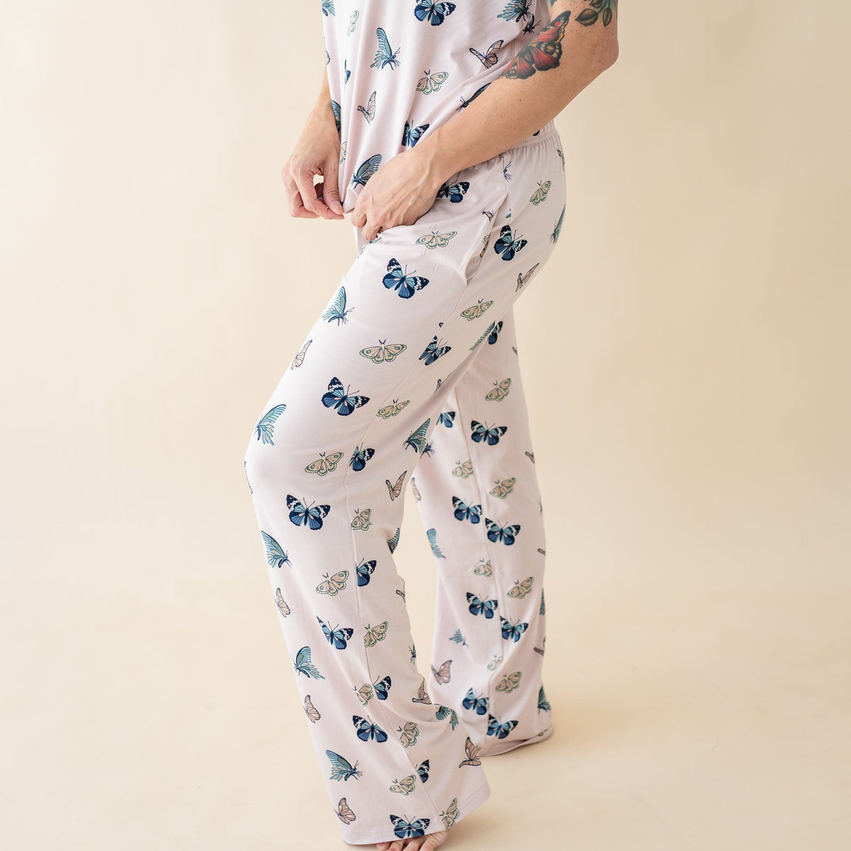 Woman wearing Kyte Baby Women's Bamboo Lounge Pants and Top in Blush Butterfly