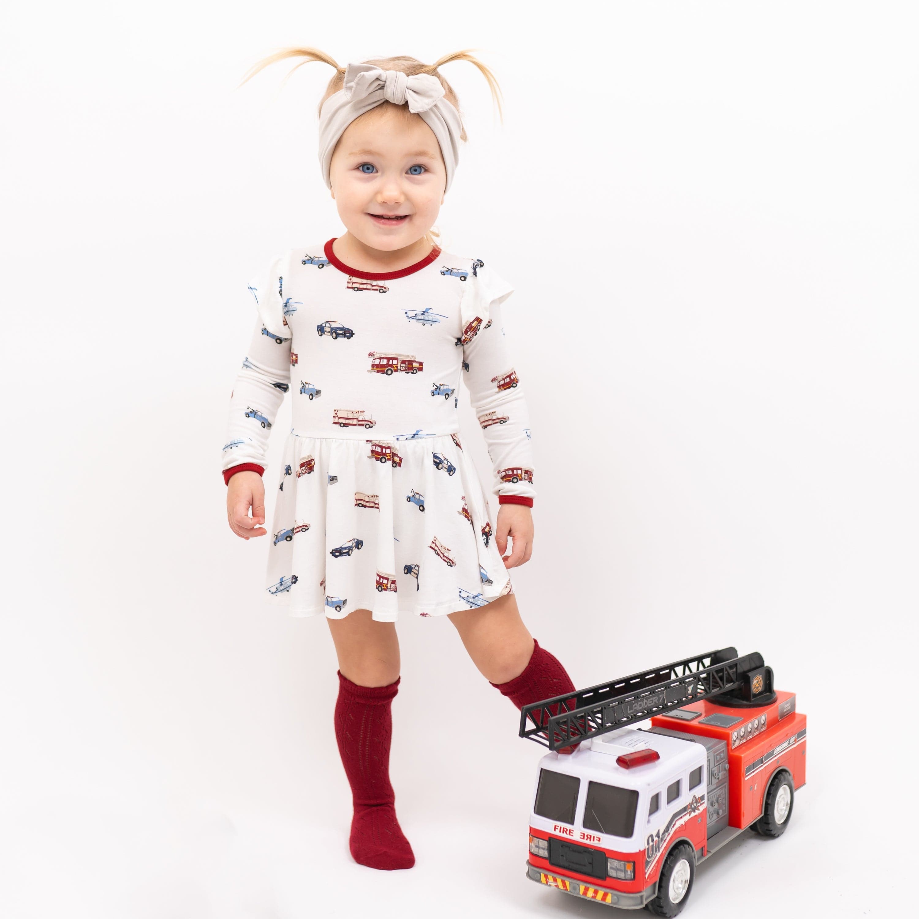 Toddler wearing bamboo Kyte Baby Twirl Bodysuit in First Responder