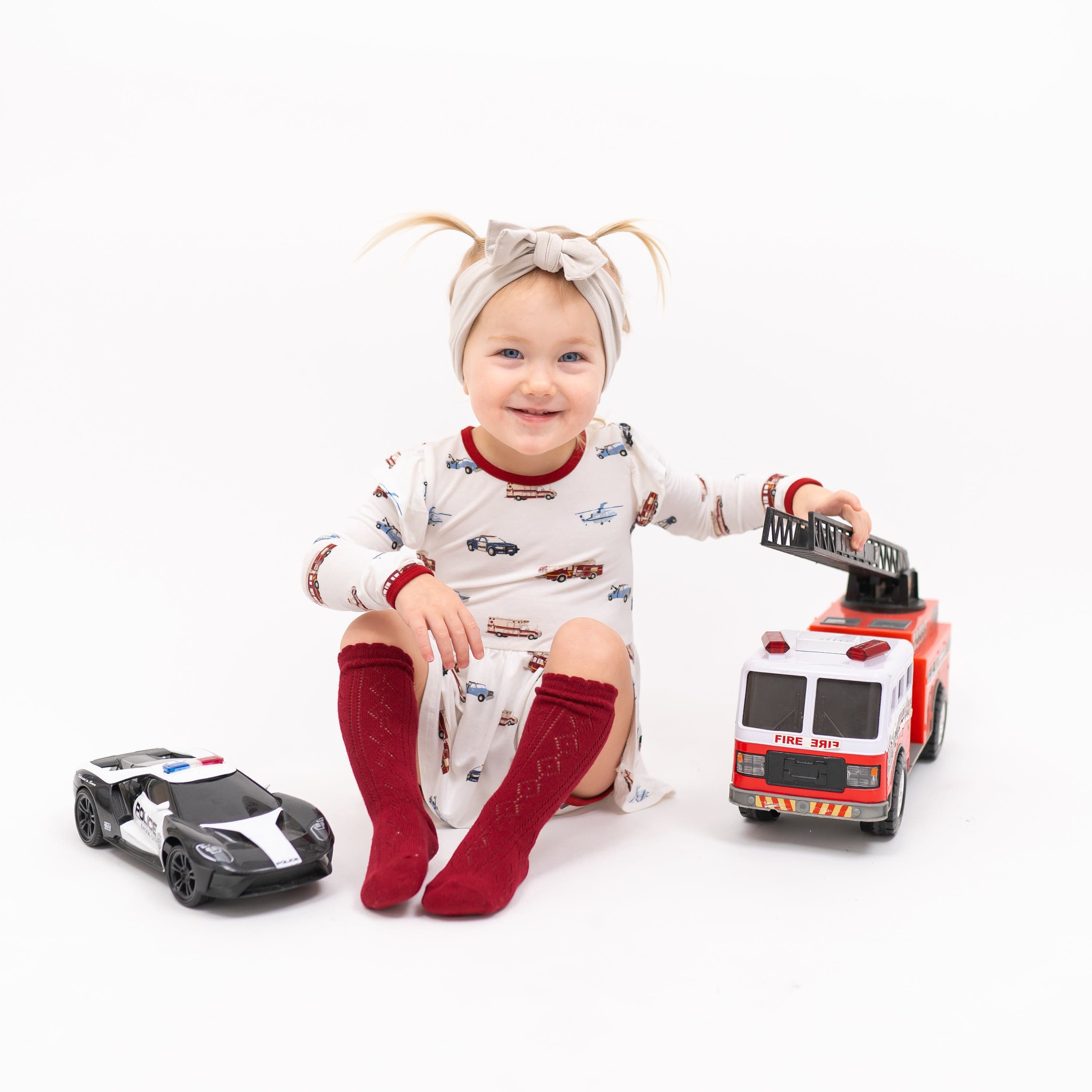 Toddler wearing bamboo Kyte Baby Twirl Bodysuit in First Responder print