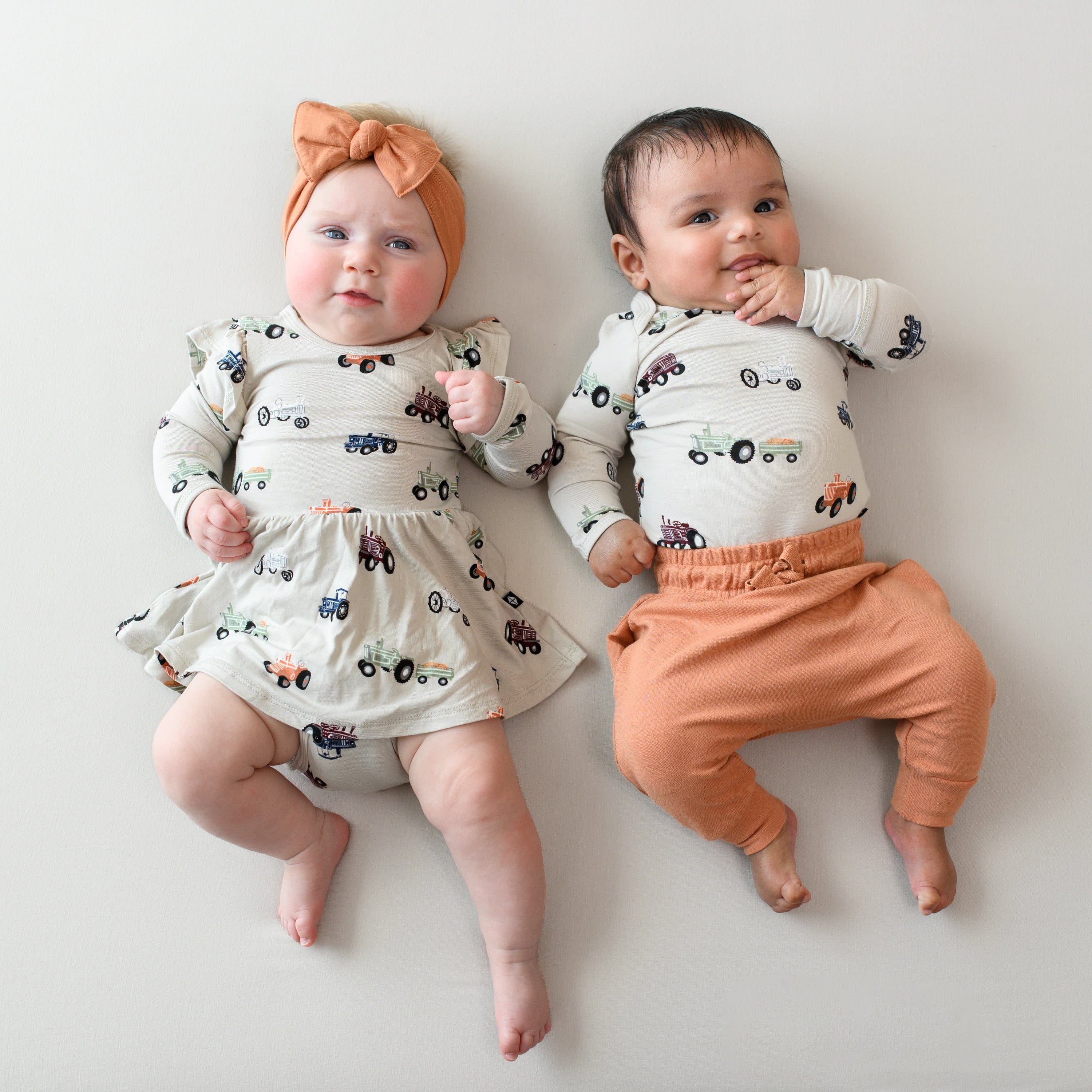 Babies wearing matching Kyte Baby bamboo clothing in Tractor