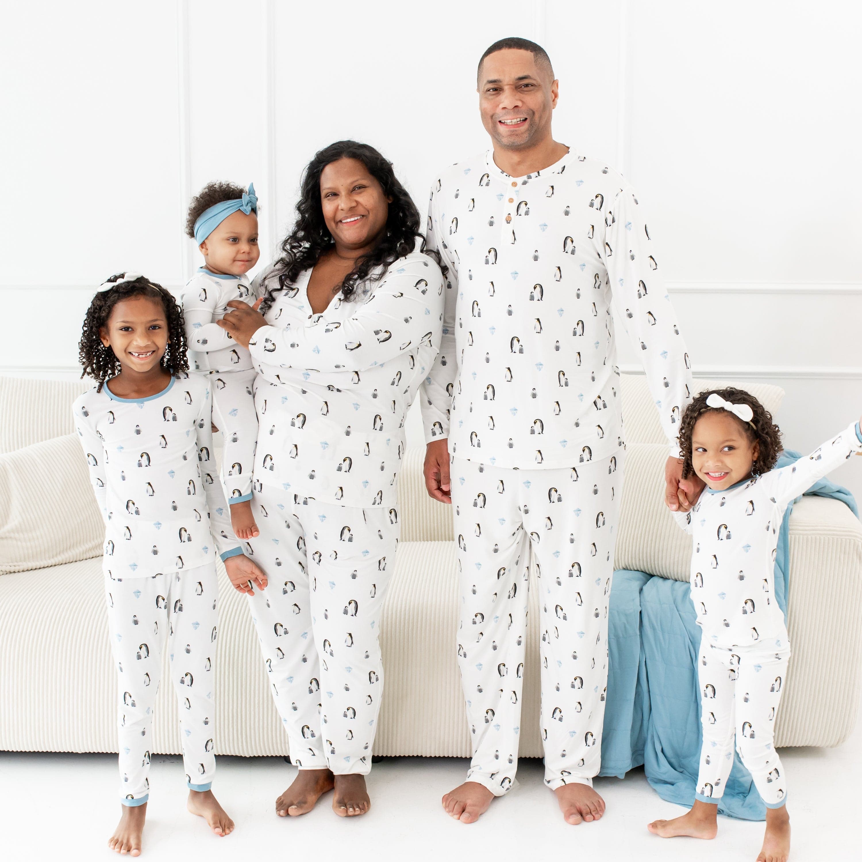 Family wearing matching Kyte Baby pajamas in Penguin print