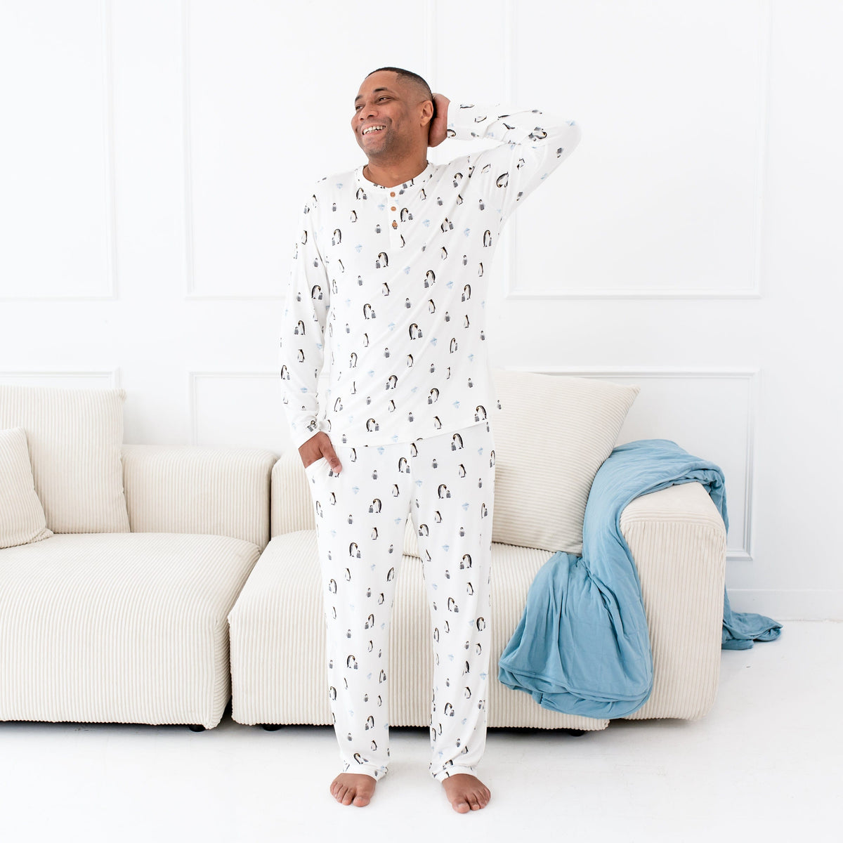 Man wearing Kyte Baby Men's Lounge Pants and Henley Top in Penguin