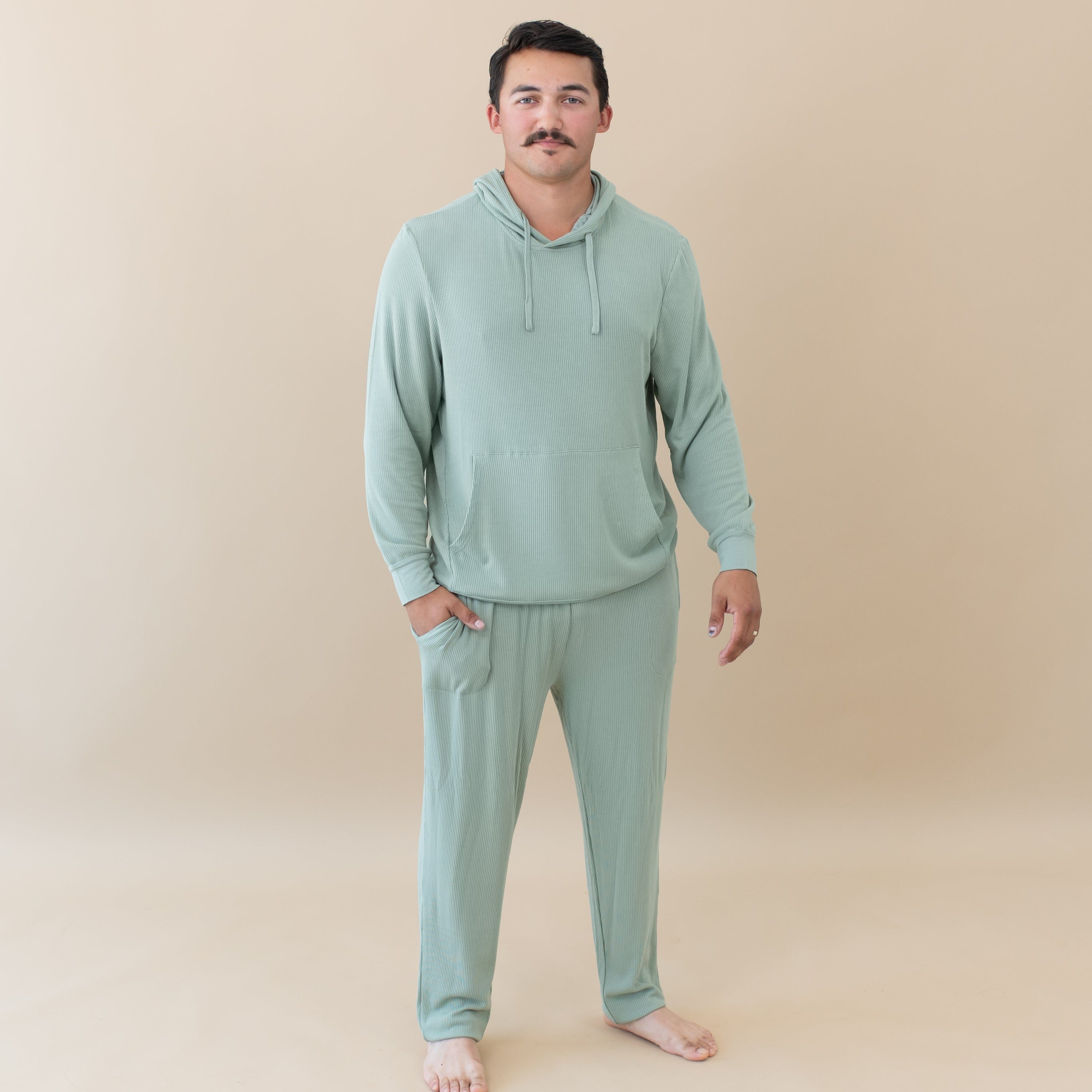 Man wearing Kyte Baby Men's Ribbed Hoodie with jogger pants in Thyme