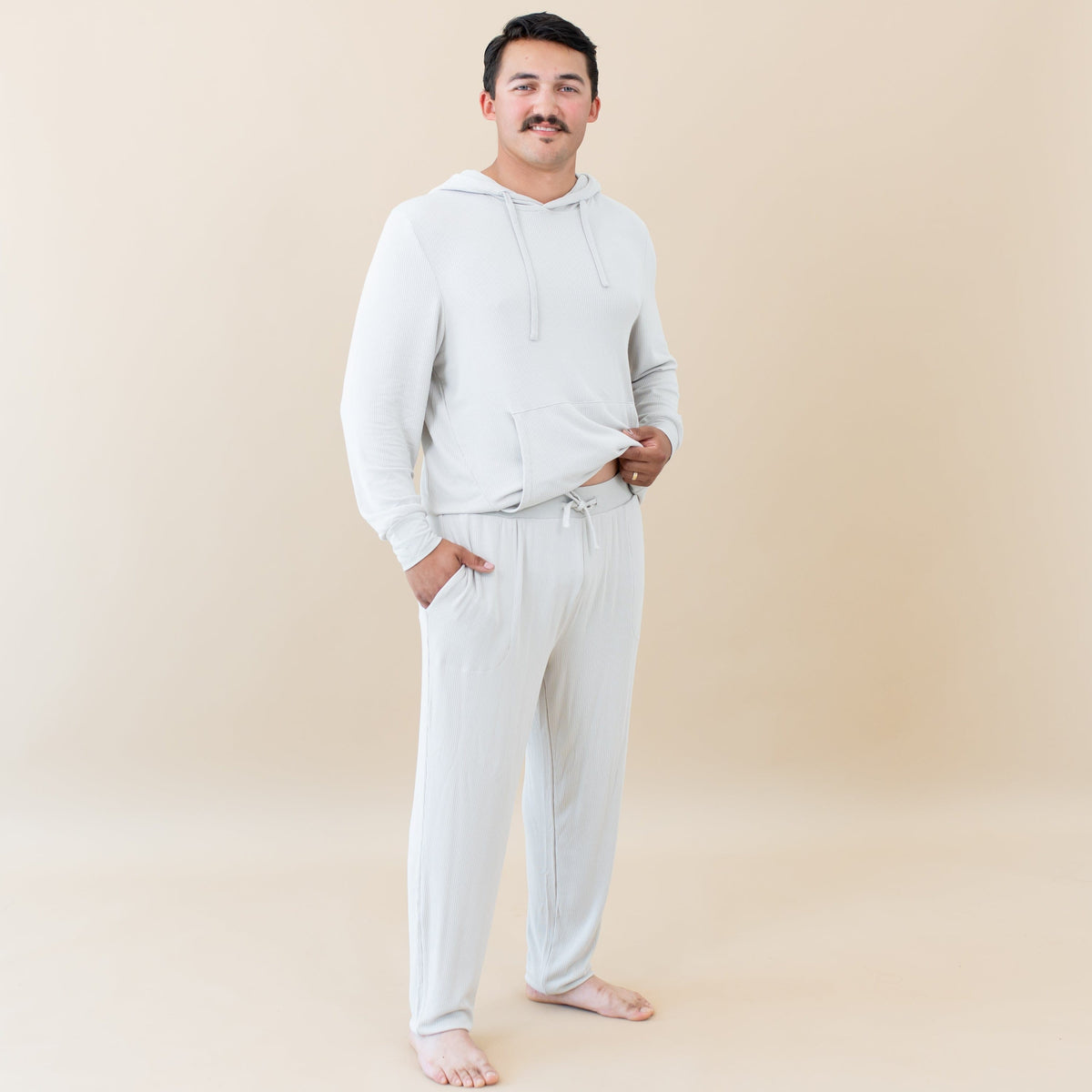 Man wearing Kyte Baby Men's Ribbed Jogger Pant with Hoodie in Oat
