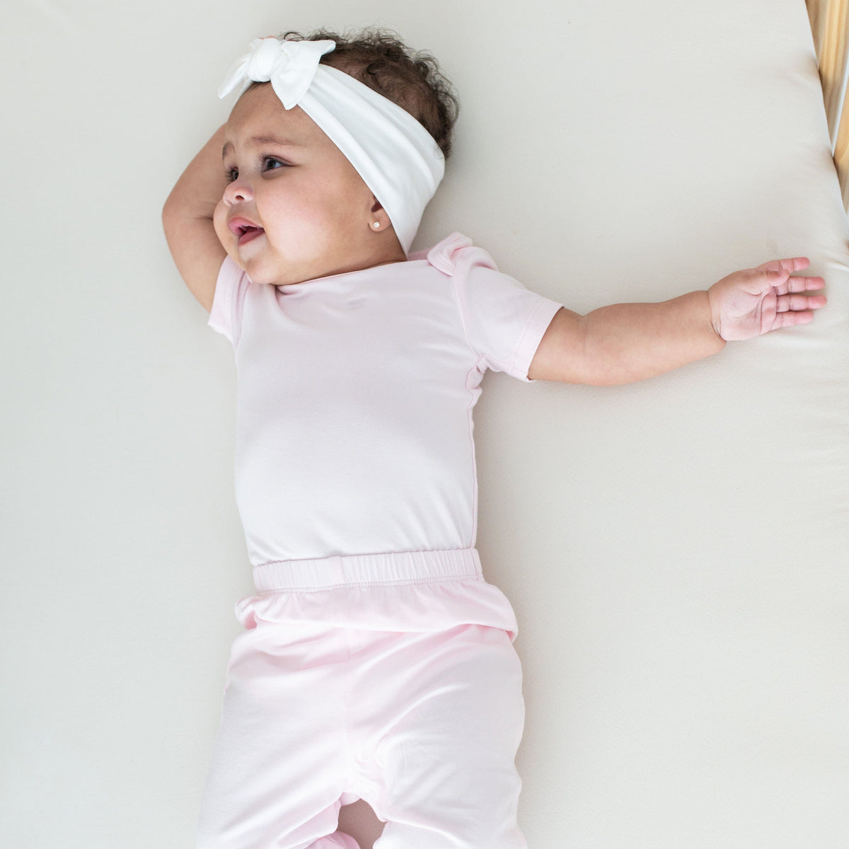 Infant wearing Kyte Baby Pants in Sakura pink