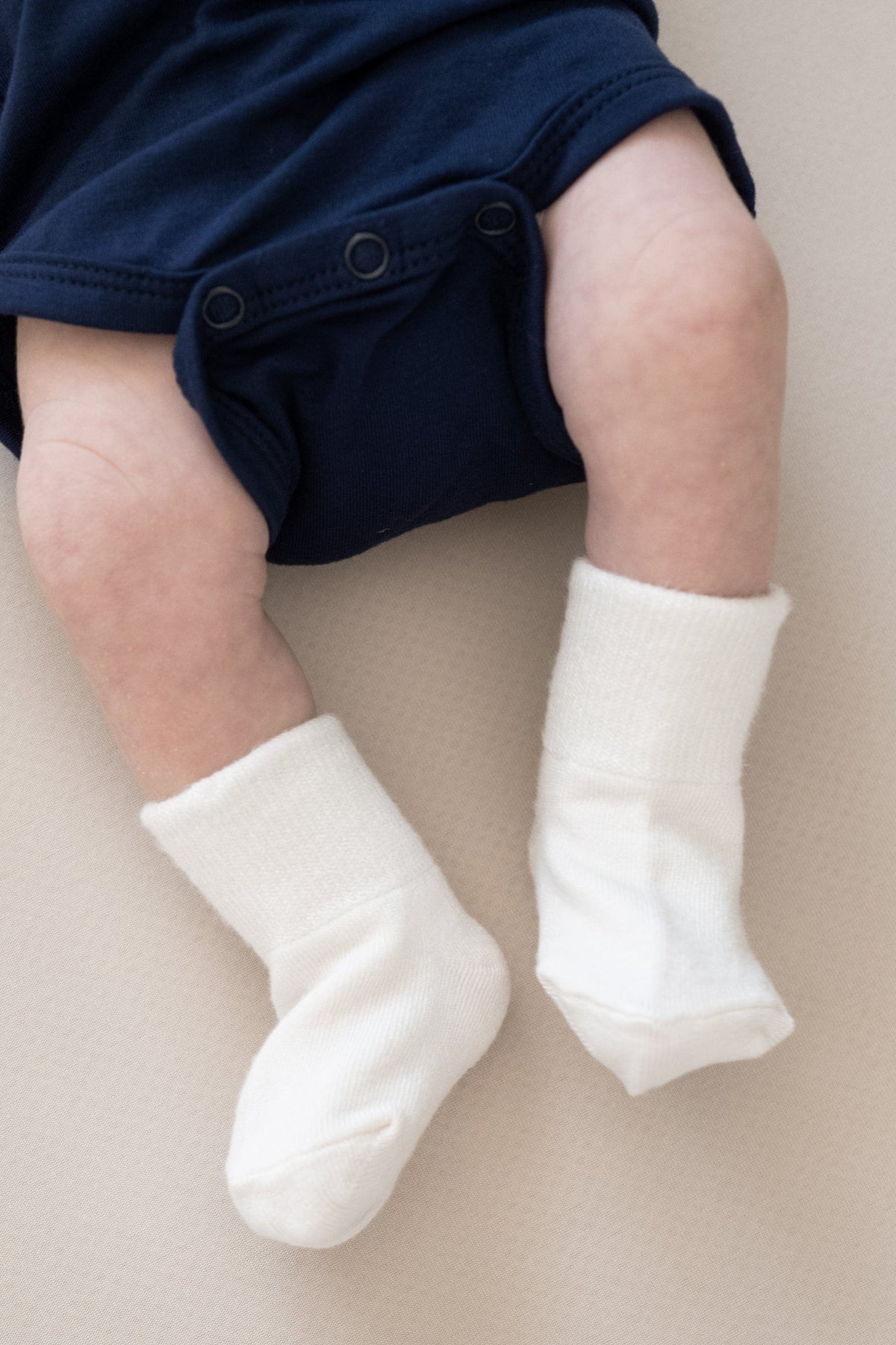 Newborn wearing Kyte Baby Quarter Socks in Cloud White