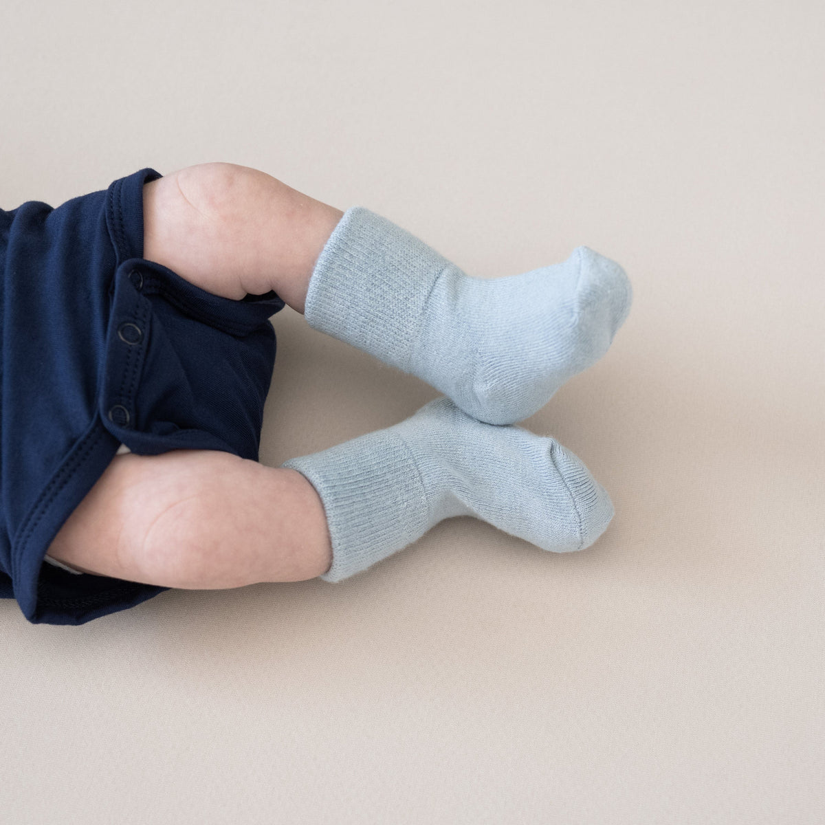 Newborn wearing Kyte Baby Quarter Socks in Cool Blue