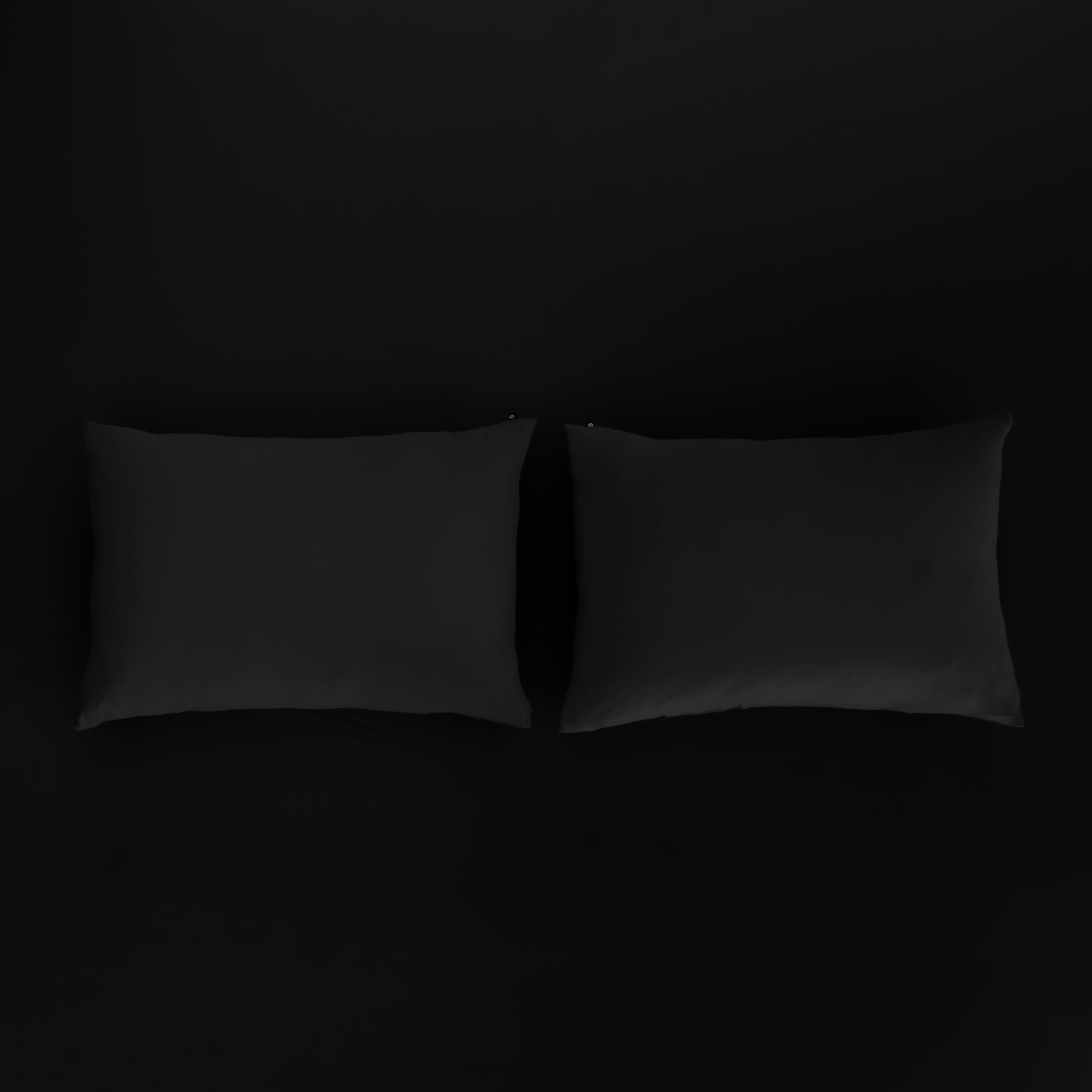 Kyte Baby Pillowcases in Midnight sitting on fitted sheet