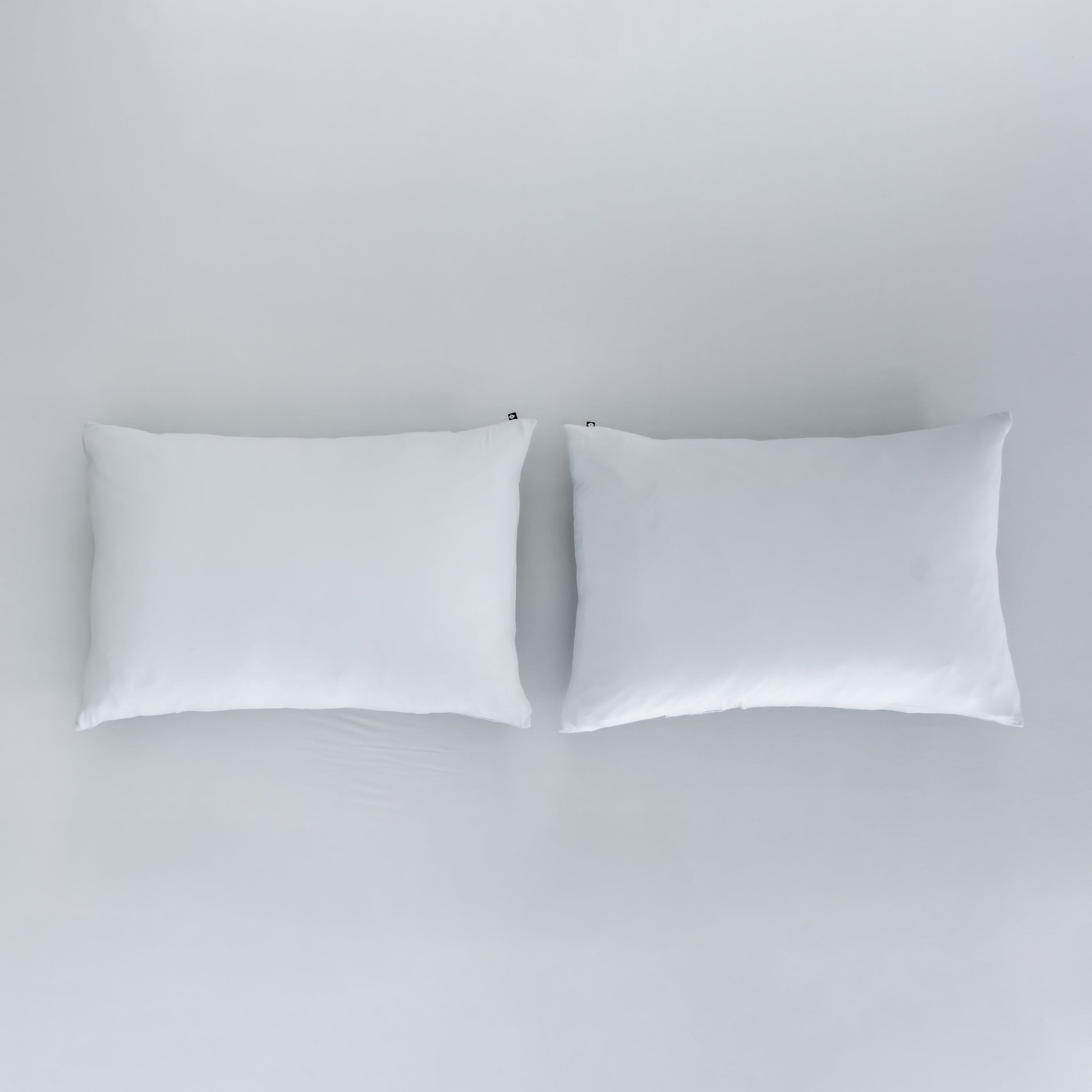 Kyte Baby Pillowcases in Storm sitting on top of Fitted Sheet